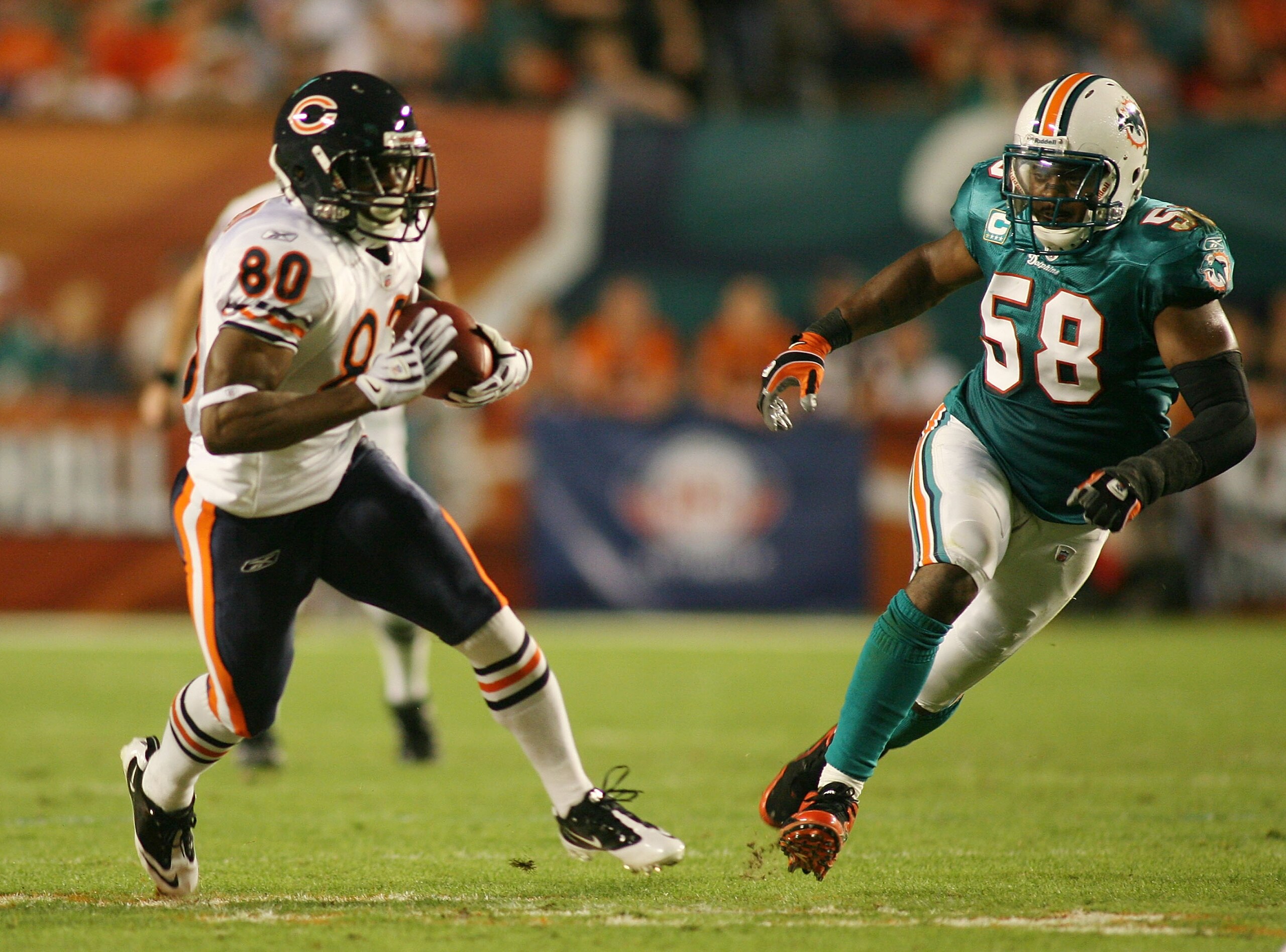 MIAMI - NOVEMBER 18:  Receiver Earl Bennett #80 of the Chicago Bears runs from linebacker Karlos Dansby #58 of the Miami Dolphins at Sun Life Stadium on November 18, 2010 in Miami, Florida.  (Photo by Marc Serota/Getty Images)