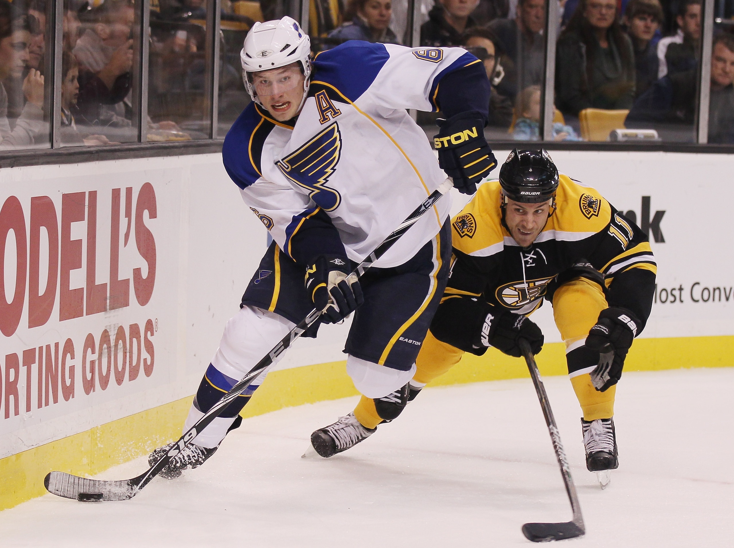 BOSTON - NOVEMBER 06:  Erik Johnson #6 of the St. Louis Blues takes the puck behind the net as Gregory Campbell #11 of the Boston Bruins defends on November 6, 2010 at the TD Garden in Boston, Massachusetts.  (Photo by Elsa/Getty Images)