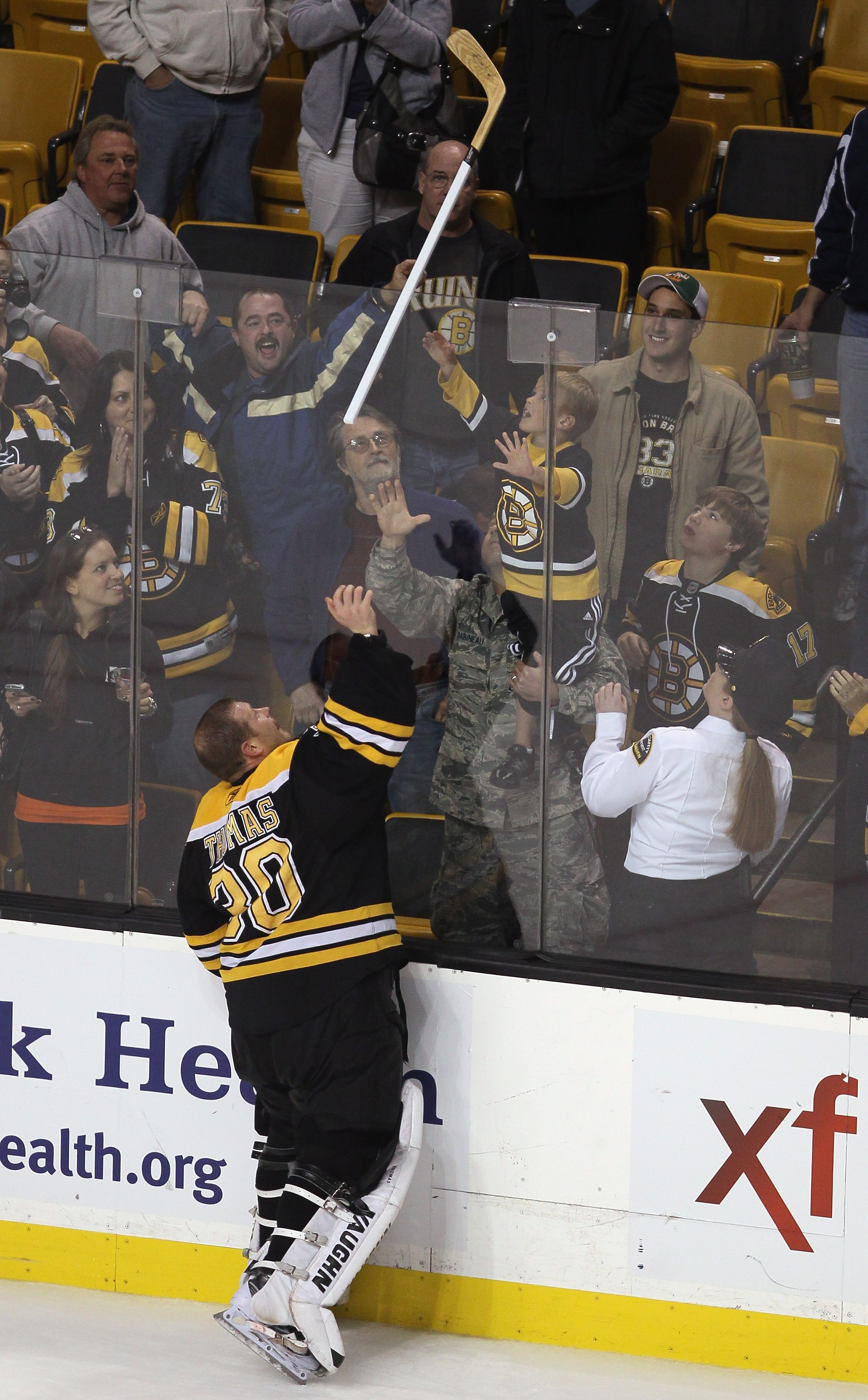 BOSTON - NOVEMBER 15:  Tim Thomas #30 of the Boston Bruins gives a hockey stick to a fan after the game against the New Jersey Devils on November 15, 2010 at the TD Garden in Boston, Massachusetts. The Bruins shut out the Devils 3-0. (Photo by Elsa/Getty