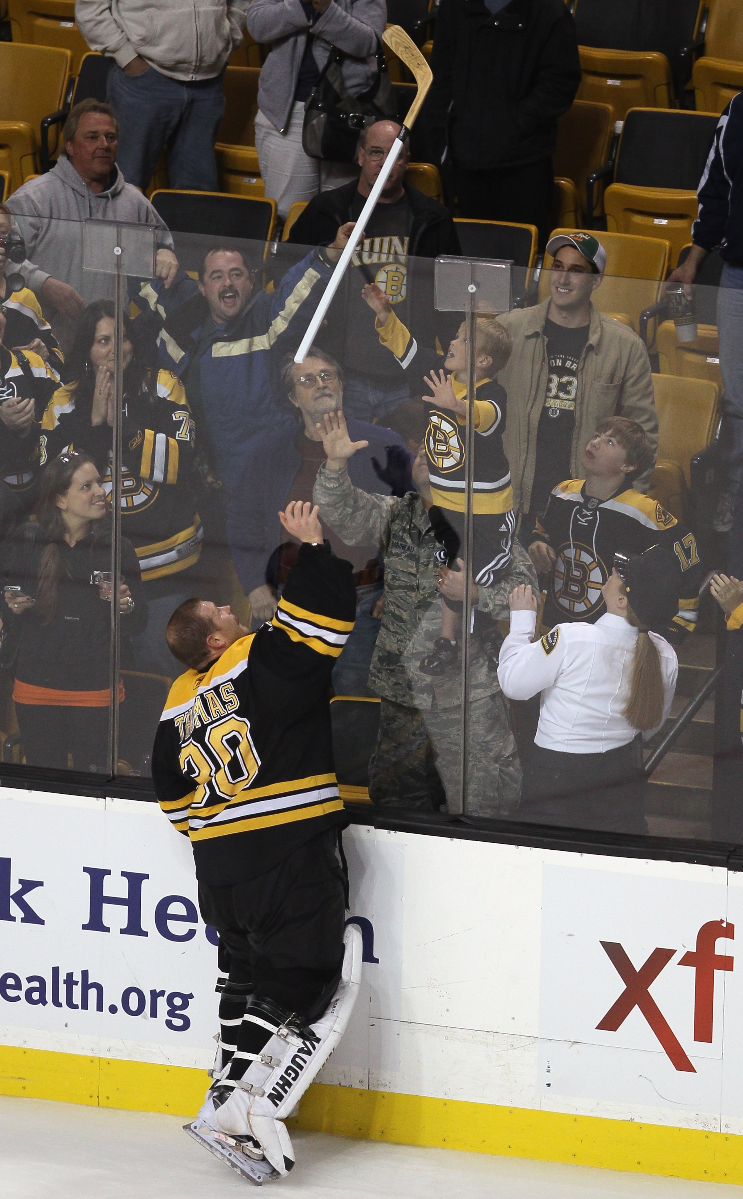 BOSTON - NOVEMBER 15:  Tim Thomas #30 of the Boston Bruins gives a hockey stick to a fan after the game against the New Jersey Devils on November 15, 2010 at the TD Garden in Boston, Massachusetts. The Bruins shut out the Devils 3-0. (Photo by Elsa/Getty