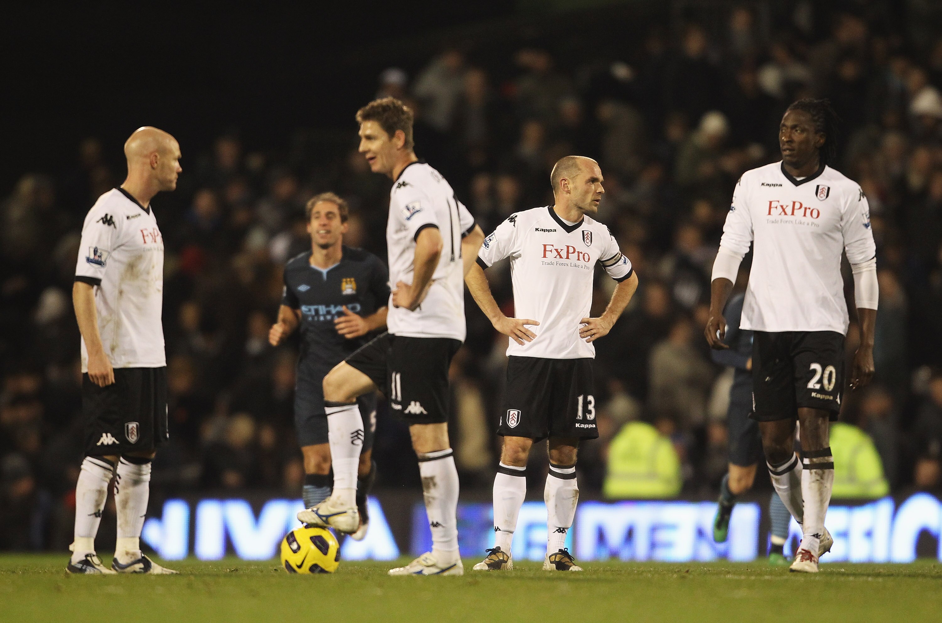 LONDON, ENGLAND - NOVEMBER 21: Danny Murphy (2ndR) of Fulham talks to Dickson Etuhu after Manchester City's fourth goal during the Barclays Premier League match between Fulham and Manchester City at Craven Cottage on November 21, 2010 in London, England.
