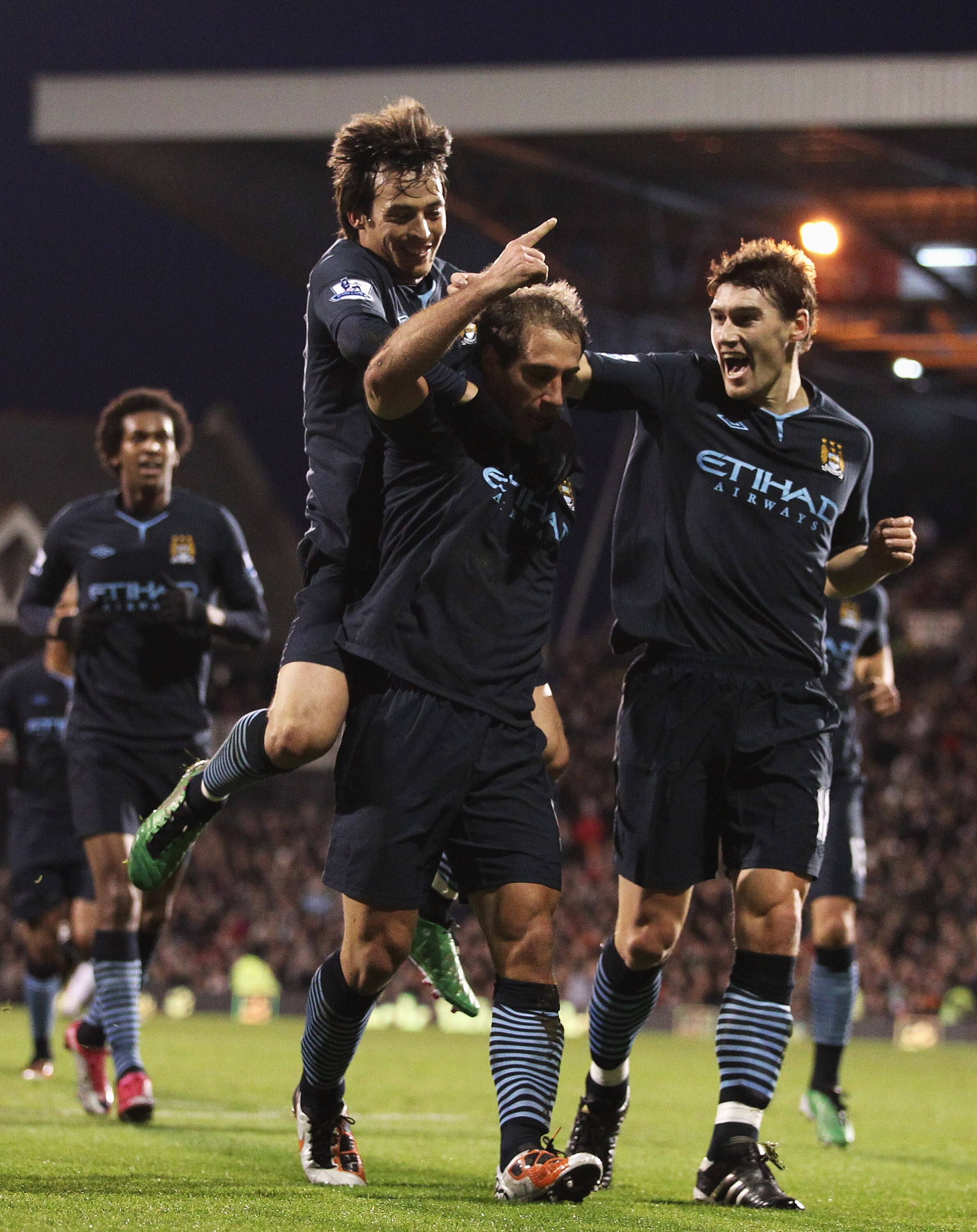 LONDON, ENGLAND - NOVEMBER 21:  Pablo Zabaleta (C) of Manchester City celebrates scoring his teams second goal with Gareth Barry (R) and David Silva during the Barclays Premier League match between Fulham and Manchester City at Craven Cottage on November