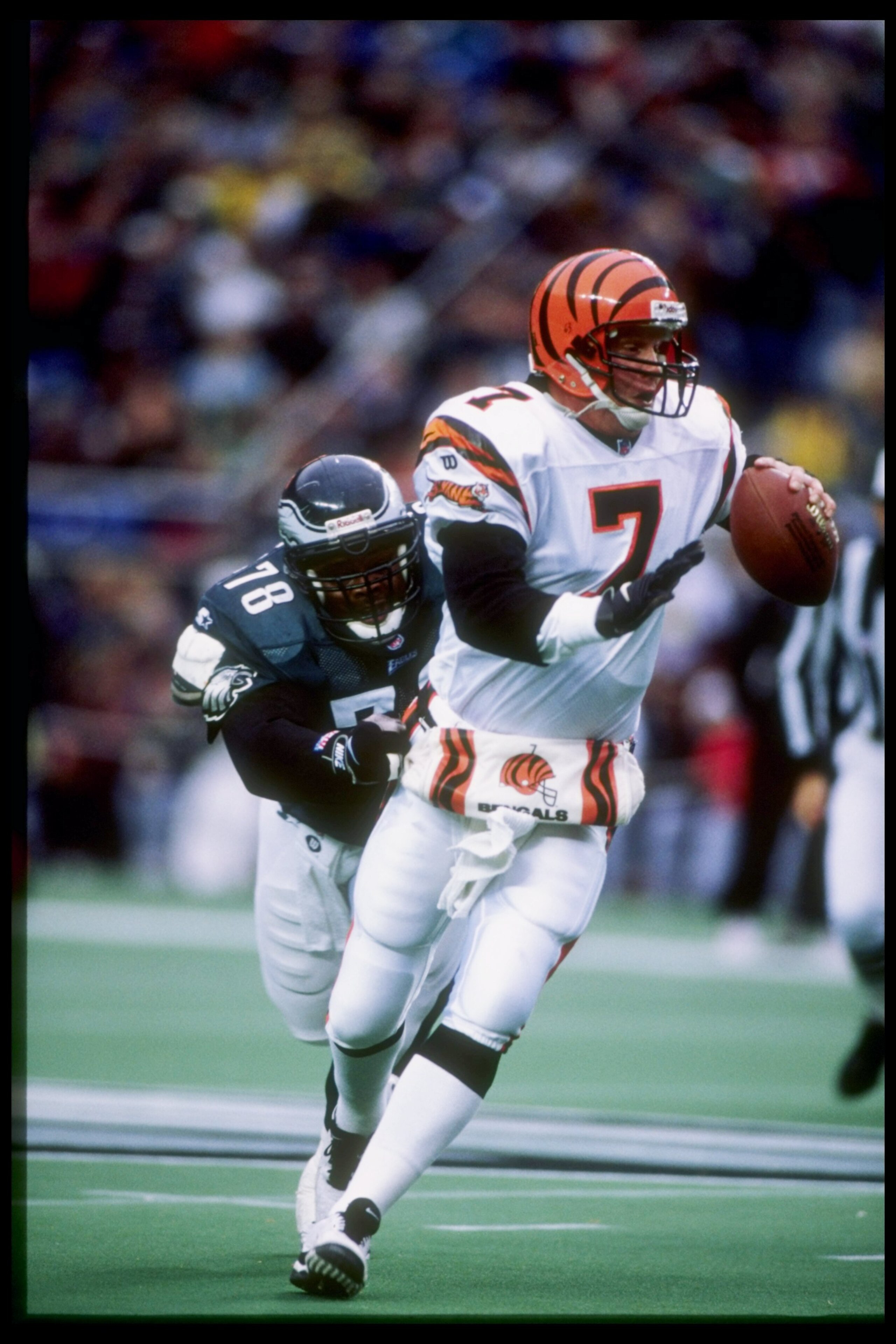 30 Nov 1997:  Quarterback Boomer Esiason of the Cincinnati Bengals tries to get away from defensive tackle Hollis Thomas of the Philadelphia Eagles during a game at Veterans Stadium in Philadelphia, Pennsylvania.  The Eagles won the game 44-42. Mandatory