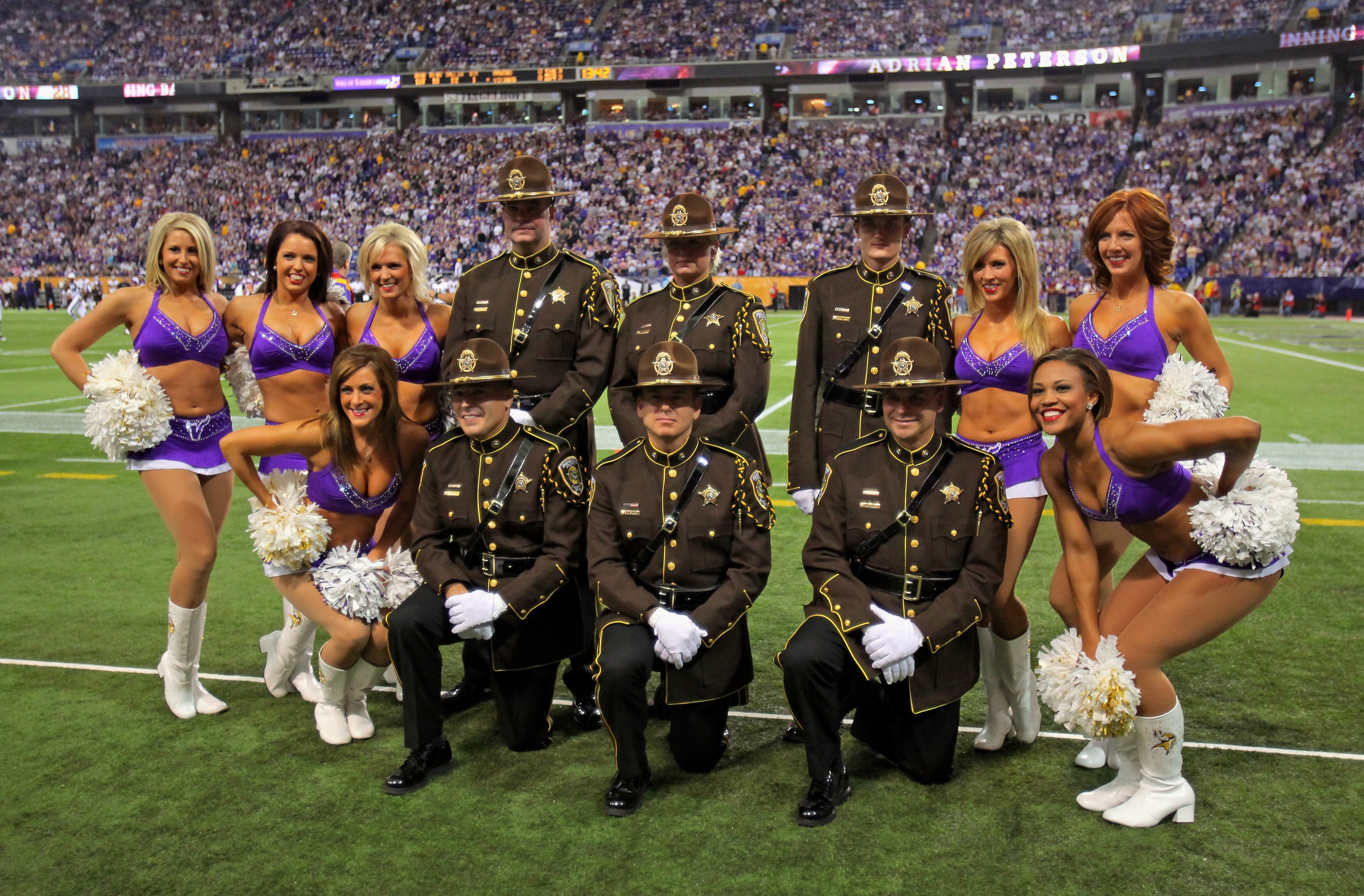 MINNEAPOLIS - OCTOBER 18:  The Minnesota Vikings cheerleaders pose for a photo with members of the Sherburne County Sheriffs Department as the Vikings face the Baltimore Ravens during NFL action at Hubert H. Humphrey Metrodome on October 18, 2009 in Minne