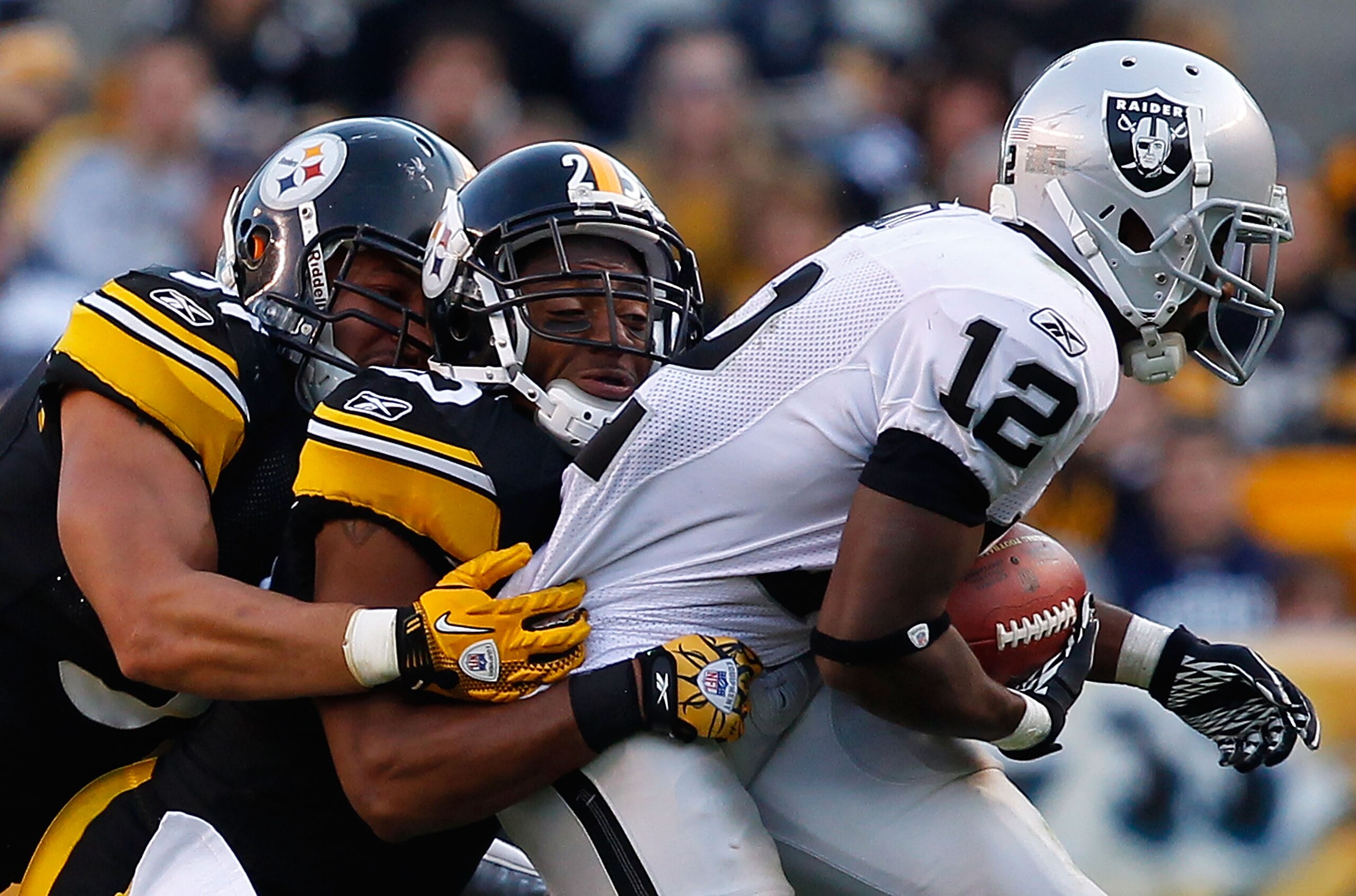 PITTSBURGH - NOVEMBER 21:  Ryan Clark #25 and James Farrior #51 of the Pittsburgh Steelers tackle Jacoby Ford #12 of the Oakland Raiders during the game on November 21, 2010 at Heinz Field in Pittsburgh, Pennsylvania.  (Photo by Jared Wickerham/Getty Imag