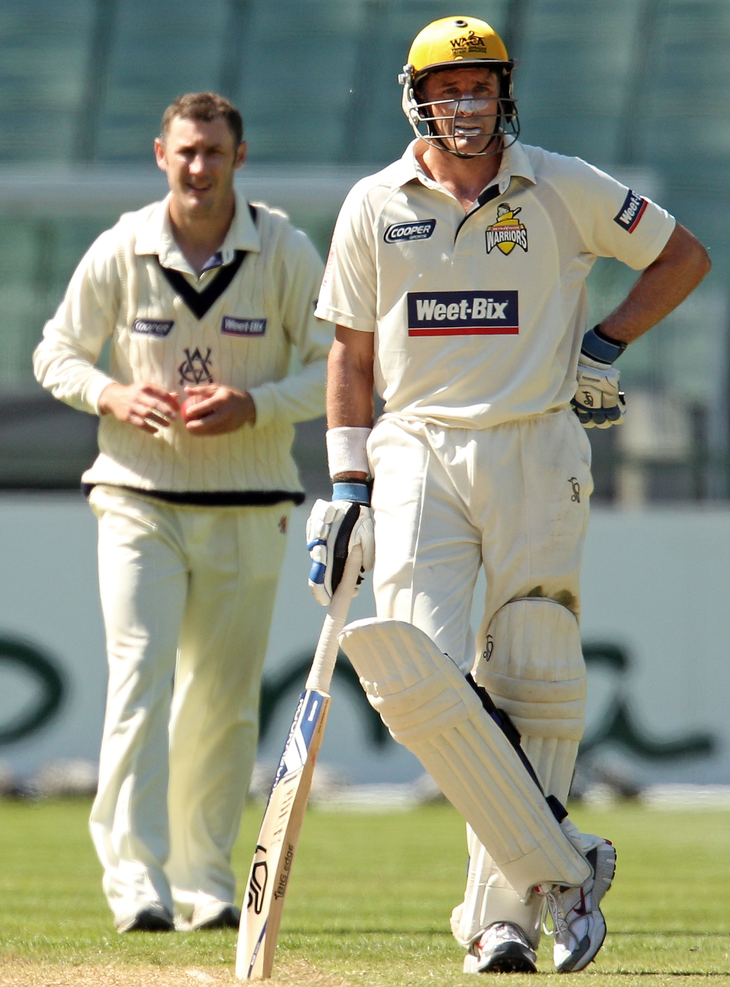 MELBOURNE, AUSTRALIA - NOVEMBER 19:  David Hussey (L) of the Bushrangers bowls as Michael Hussey of the Warriors looks on during day three of the Sheffield Shield match between the Victorian Bushrangers and the Western Australia Warriors at Melbourne Cric