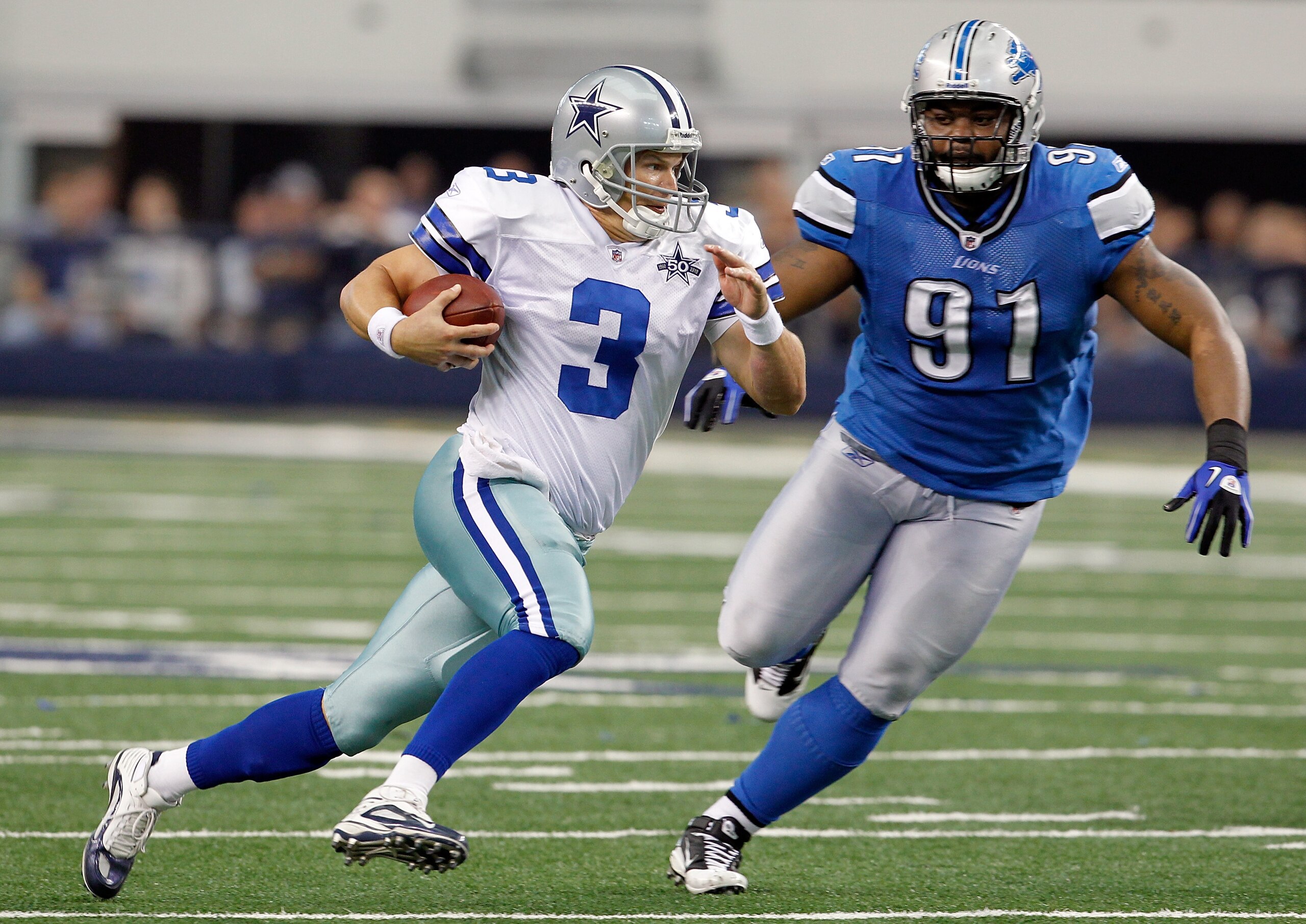 ARLINGTON, TX - NOVEMBER 21: Quarterback Jon Kitna #3 of the Dallas Cowboys scrambles with the ball against tackle Sammie Hill #91 of the Detroit Lions at Cowboys Stadium on November 21, 2010 in Arlington, Texas. The Cowboys beat the Lions 35-19. (Phot ARLINGTON, TX - NOVEMBER 21: Quarterback Jon Kitna #3 of the Dallas Cowboys scrambles with the ball against tackle Sammie Hill #91 of the Detroit Lions at Cowboys Stadium on November 21, 2010 in Arlington, Texas. The Cowboys beat the Lions 35-19. (Phot