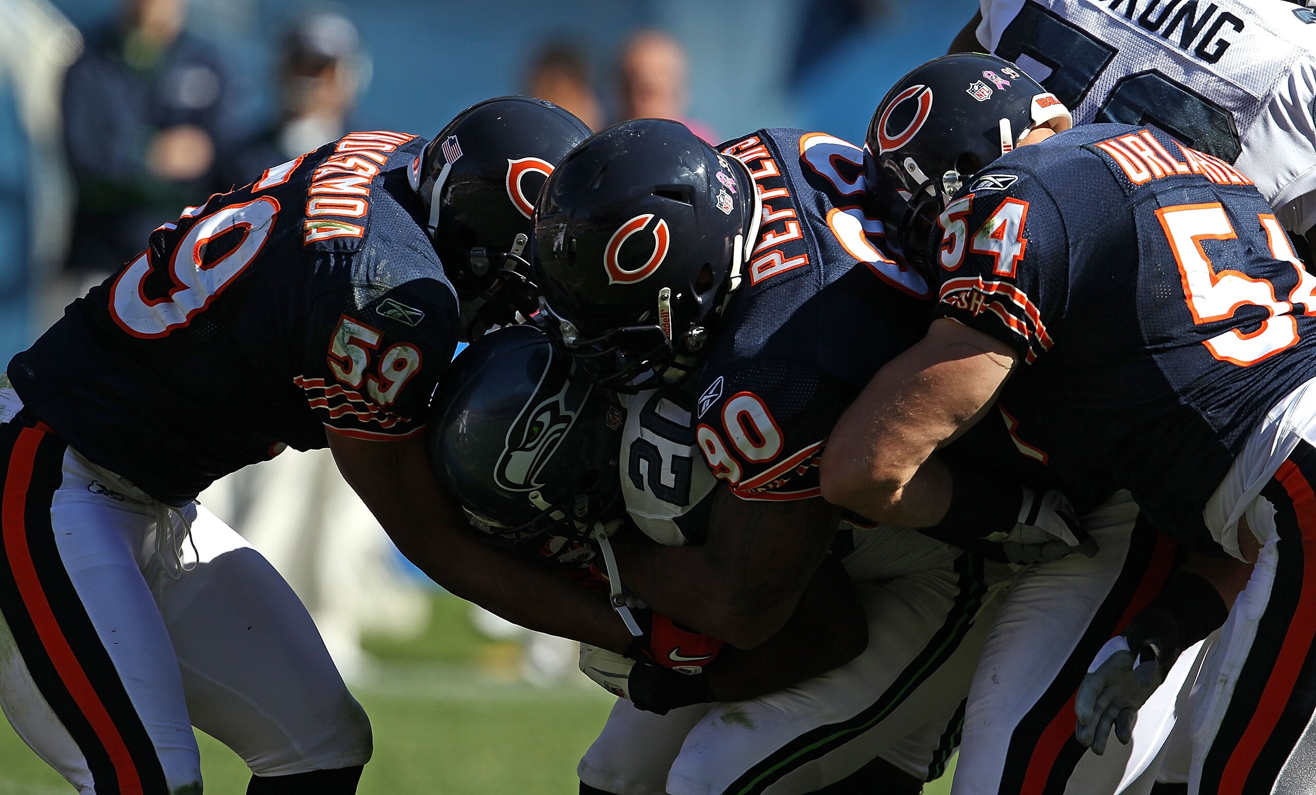 CHICAGO - OCTOBER 17: Justin Forsett #20 of the Seattle Seahawks is tackled by (L-R) Pia Tinoisamoa #59, Julius Peppers #90 and Brian Urlacher #54 of the Chicago Bears at Soldier Field on October 17, 2010 in Chicago, Illinois. The Seahawks defeated the Be