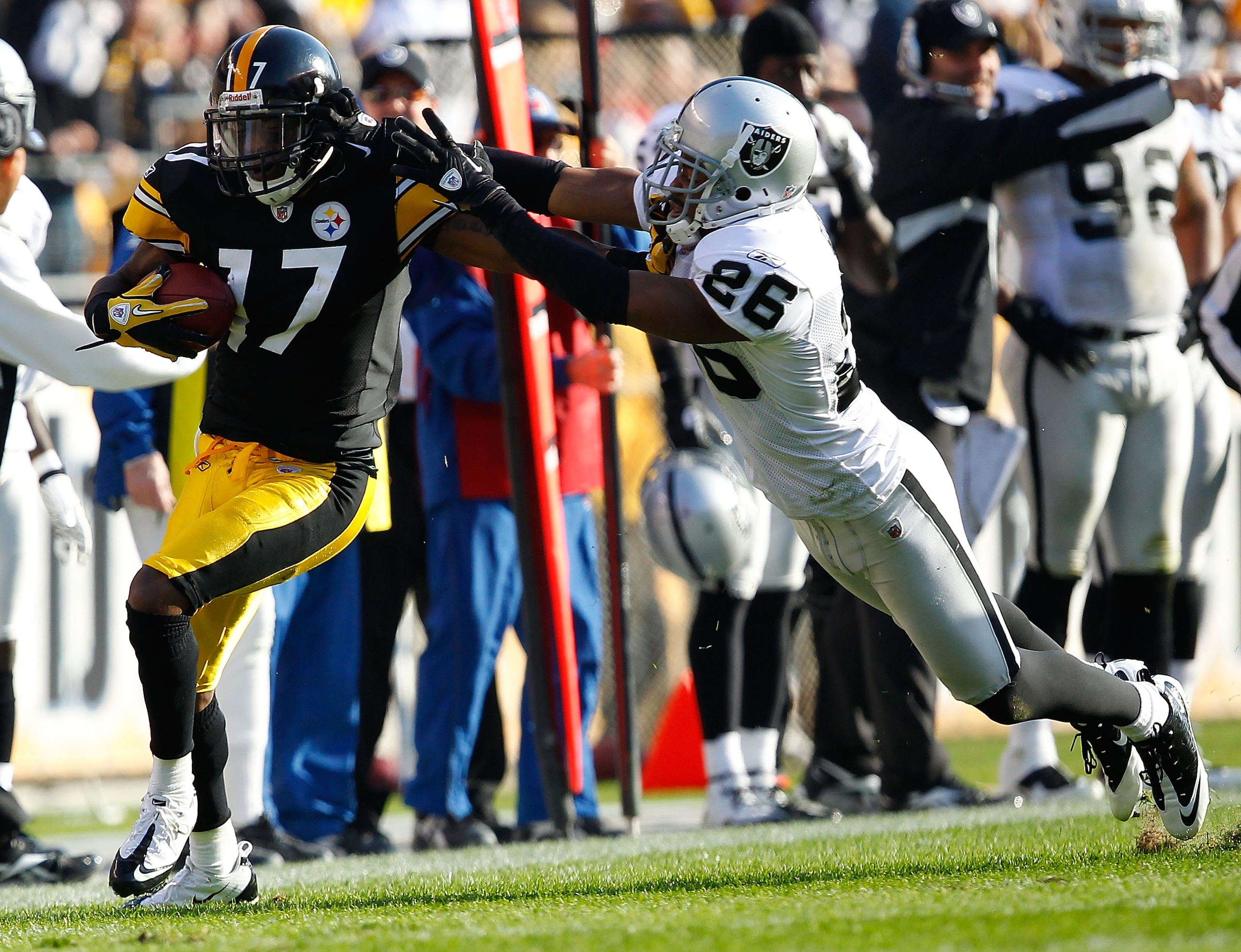 PITTSBURGH - NOVEMBER 21: Mike Wallace #17 of the Pittsburgh Steelers attempts to outrun a tackle by Stanford Routt #26 of the Oakland Raiders during the game on November 21, 2010 at Heinz Field in Pittsburgh, Pennsylvania. (Photo by Jared Wickerham/Get PITTSBURGH - NOVEMBER 21: Mike Wallace #17 of the Pittsburgh Steelers attempts to outrun a tackle by Stanford Routt #26 of the Oakland Raiders during the game on November 21, 2010 at Heinz Field in Pittsburgh, Pennsylvania. (Photo by Jared Wickerham/Get