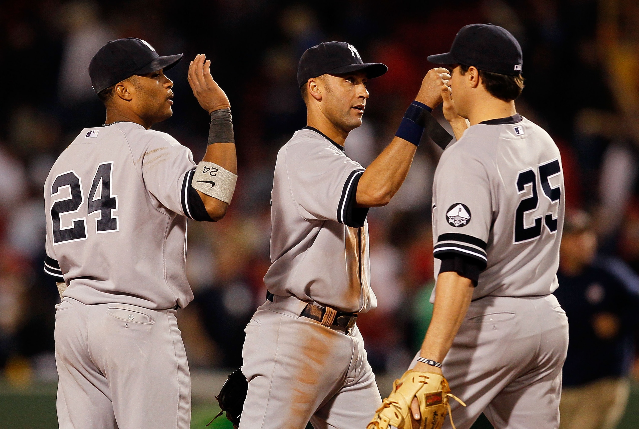 BOSTON - OCTOBER 2:  Derek Jeter #2, Mark Teixeira #25, and Robinson Cano #24 of the New York Yankees react after defeating the Boston Red Sox, 6-5, after the first game of a doubleheader at Fenway Park October 2, 2010 in Boston, Massachusetts. The Yankee