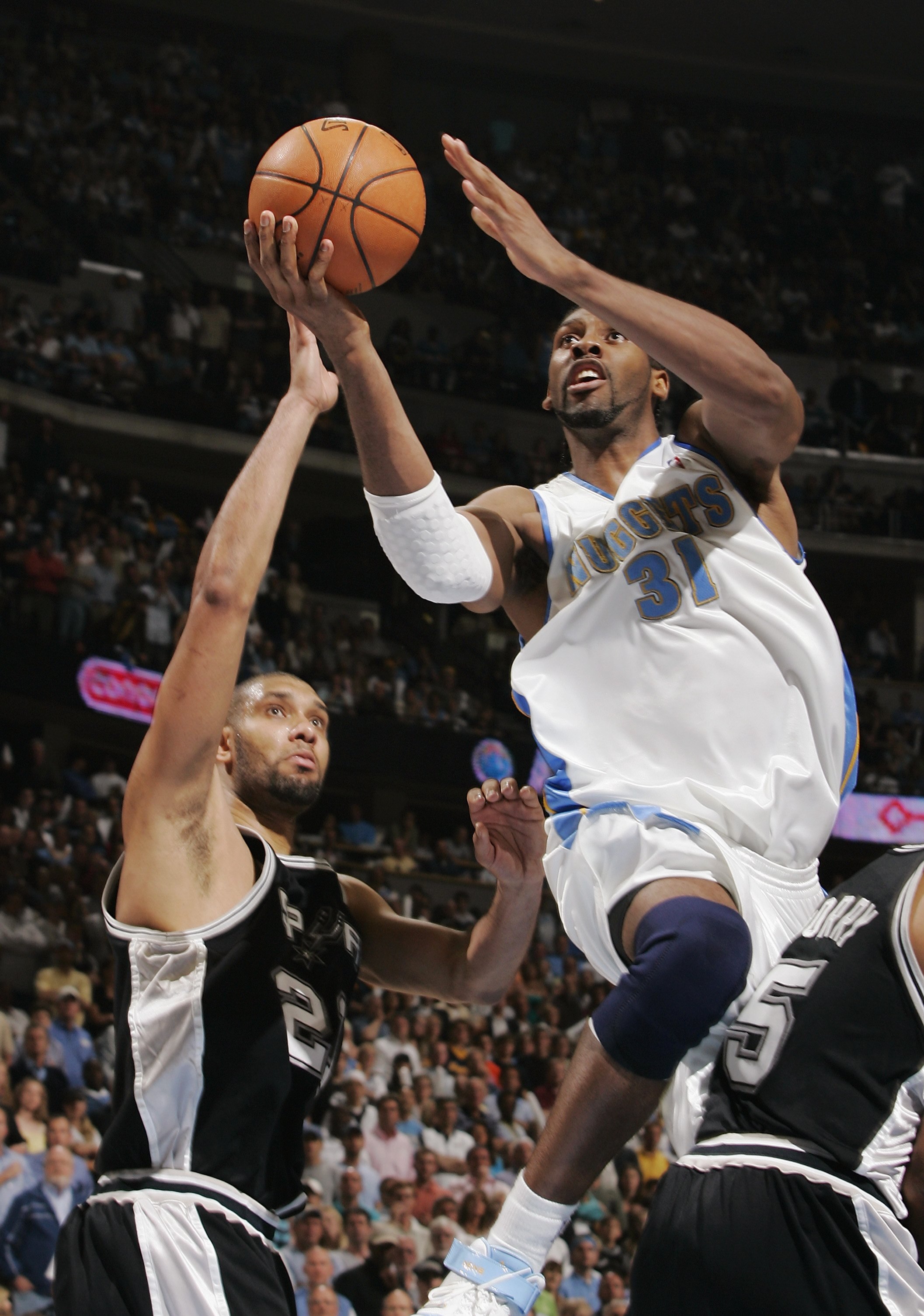 DENVER - APRIL 30:  Nen? #31 of the Denver Nuggets puts a shot up over Tim Duncan #21 of the San Antonio Spurs in Game Four of the Western Conference Quarterfinals during the 2007 NBA Playoffs at the Pepsi Center on April 30, 2007 in Denver, Colorado.  Th