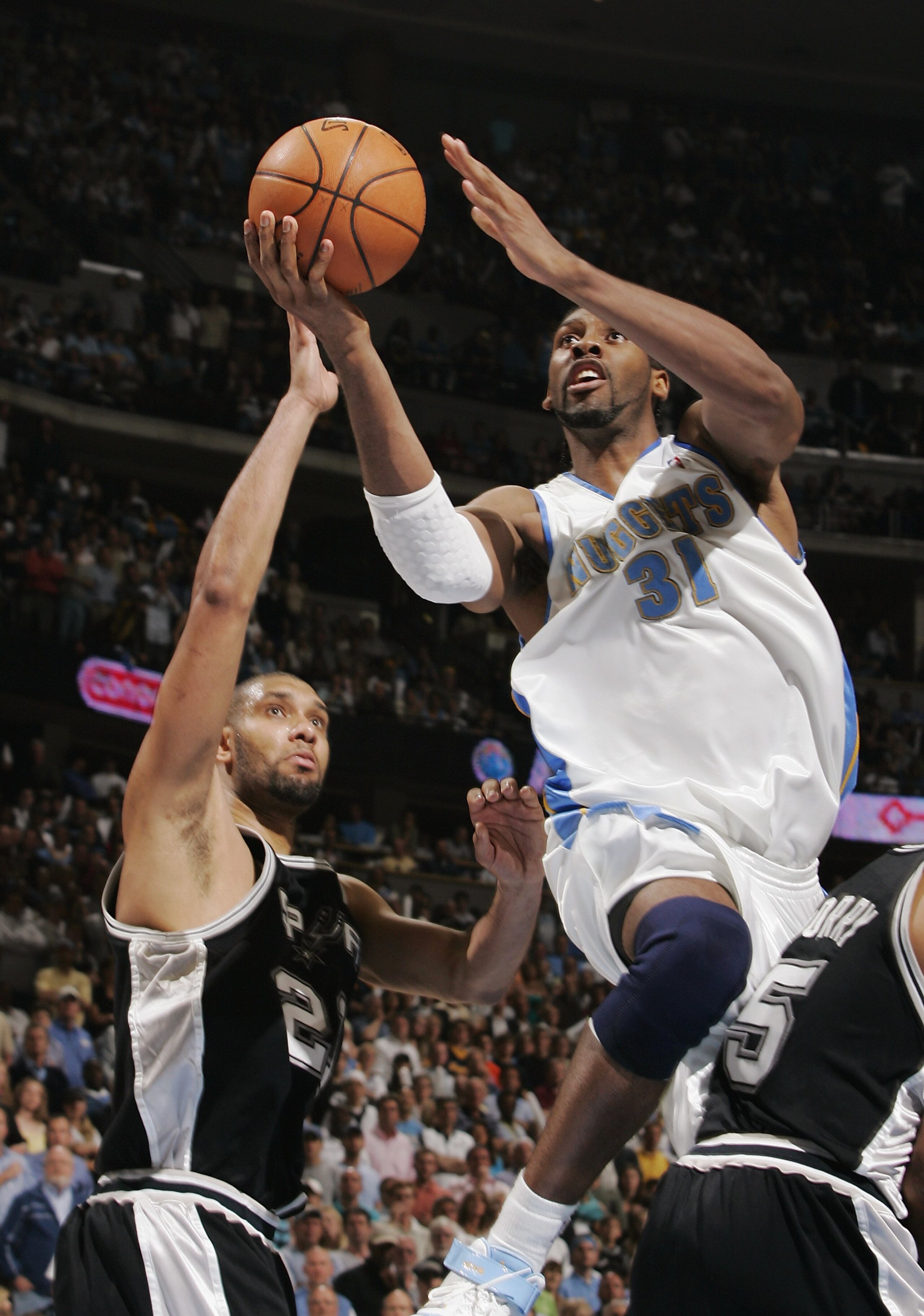DENVER - APRIL 30:  Nen? #31 of the Denver Nuggets puts a shot up over Tim Duncan #21 of the San Antonio Spurs in Game Four of the Western Conference Quarterfinals during the 2007 NBA Playoffs at the Pepsi Center on April 30, 2007 in Denver, Colorado.  Th
