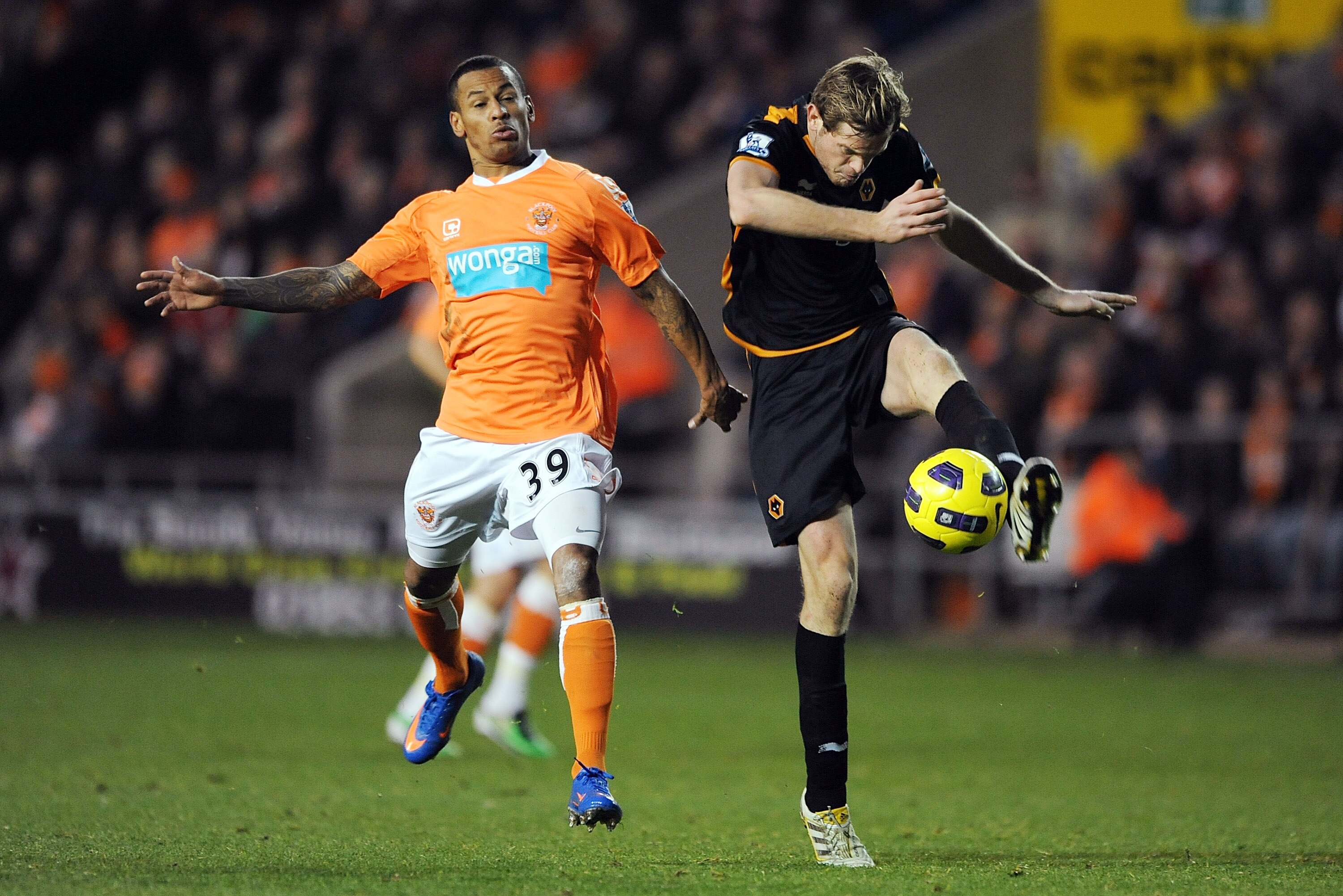 BLACKPOOL, ENGLAND - NOVEMBER 20:  Richard Stearman of Wolverhampton Wanderers clears the ball as DJ Campbell of Blackpool closes in during the Barclays Premier League match between Blackpool and Wolverhampton Wanderers at Bloomfield Road on November 20,