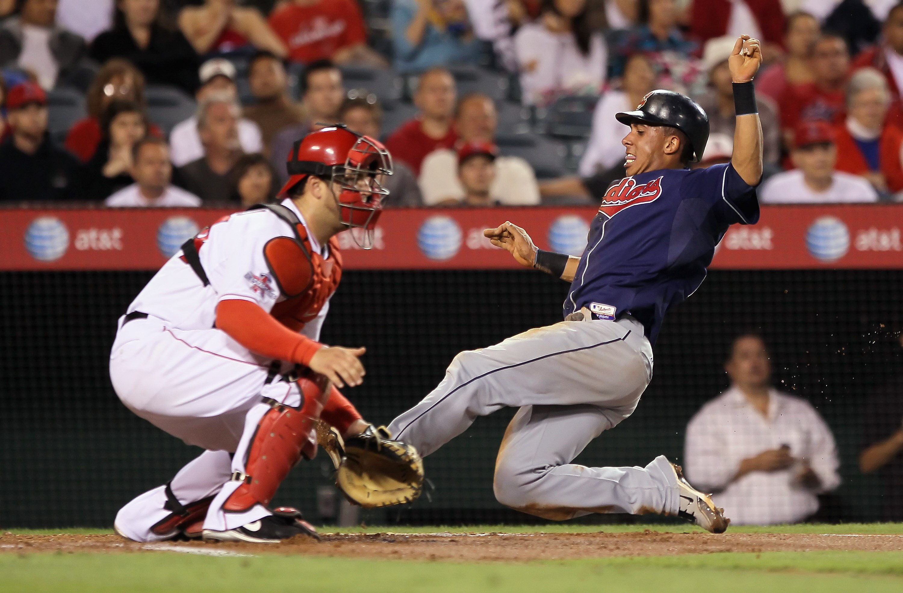 ANAHEIM, CA - SEPTEMBER 07:  Michael Brantley #23 of the Cleveland Indians slides safely past catcher Mike Napoli #44 of the Los Angeles Angels of Anaheim on a sacrifice fly by Shin-Soo Choo in the third inning at Angel Stadium on September 7, 2010 in Ana