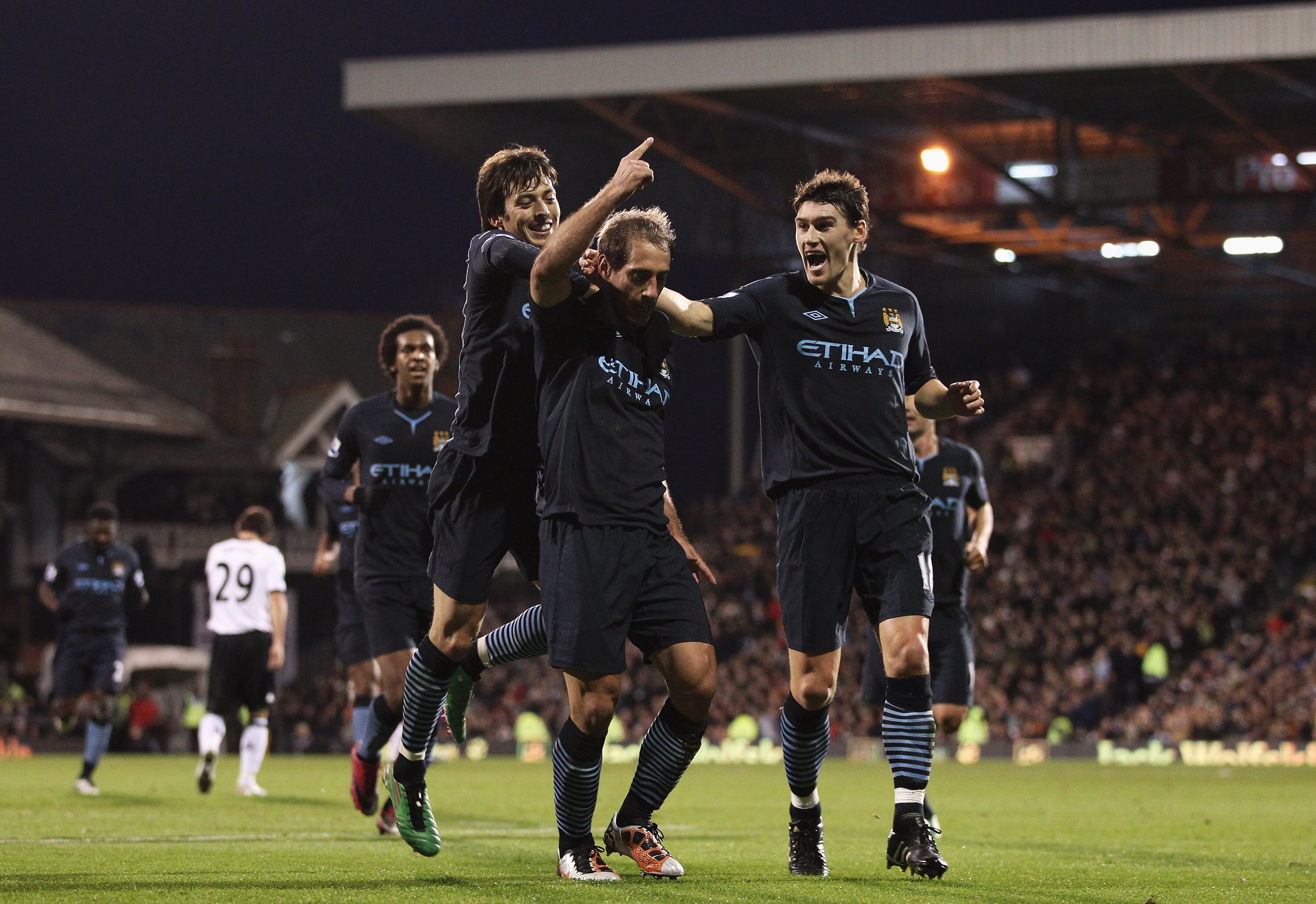 LONDON, ENGLAND - NOVEMBER 21:  Pablo Zabaleta (C) of Manchester City celebrates scoring his teams second goal with Gareth Barry (R) and David Silva during the Barclays Premier League match between Fulham and Manchester City at Craven Cottage on November