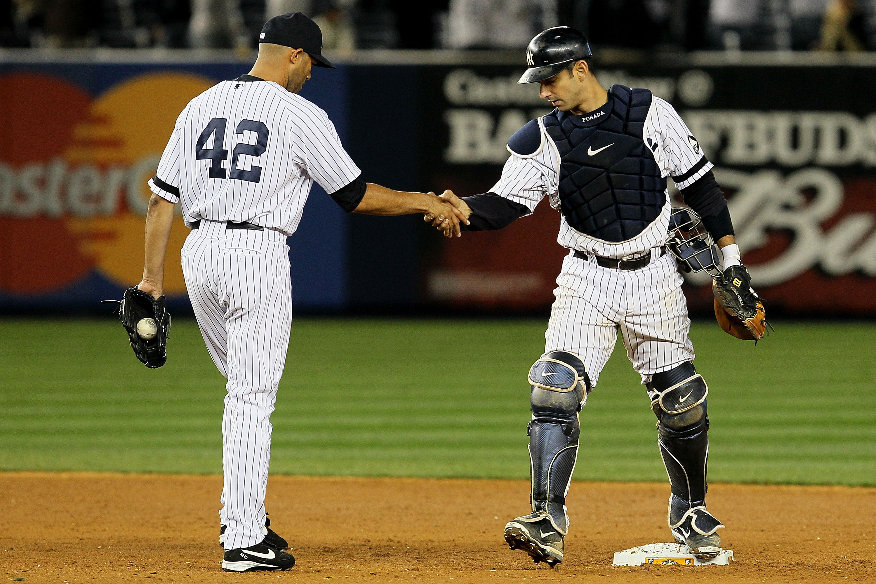 NEW YORK - OCTOBER 20:  Mariano Rivera #42 and Jorge Posada #20 of the New York Yankees celebrate after the Yankees won 7-2 against the Texas Rangers in Game Five of the ALCS during the 2010 MLB Playoffs at Yankee Stadium on October 20, 2010 in the Bronx