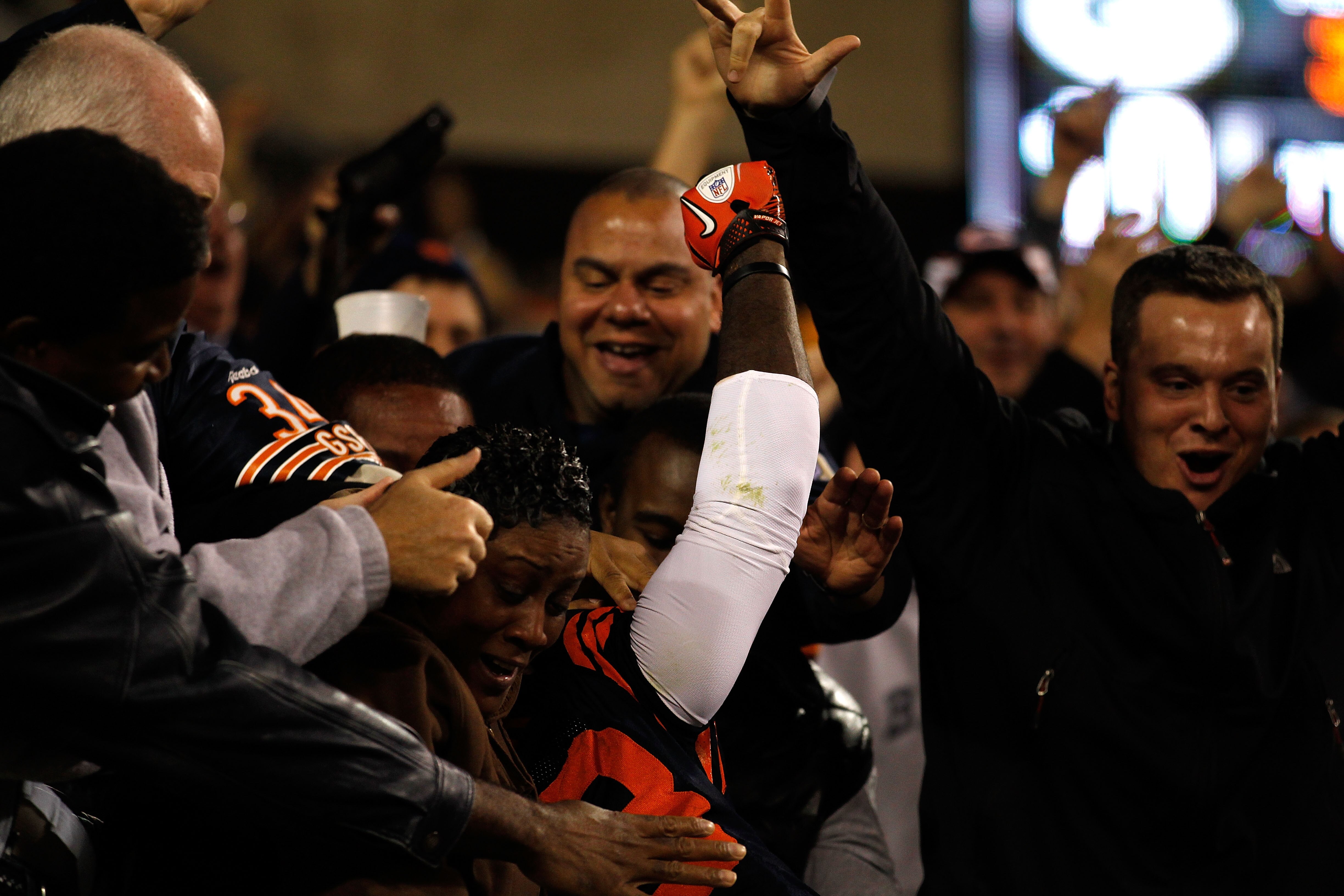 CHICAGO - SEPTEMBER 27:  Devin Hester #23 of the Chicago Bears climbs up into the stands to celebrate with fans after he scored a 62-yard punt return touchdown in the fourth quarter against the Green Bay Packers at Soldier Field on September 27, 2010 in C