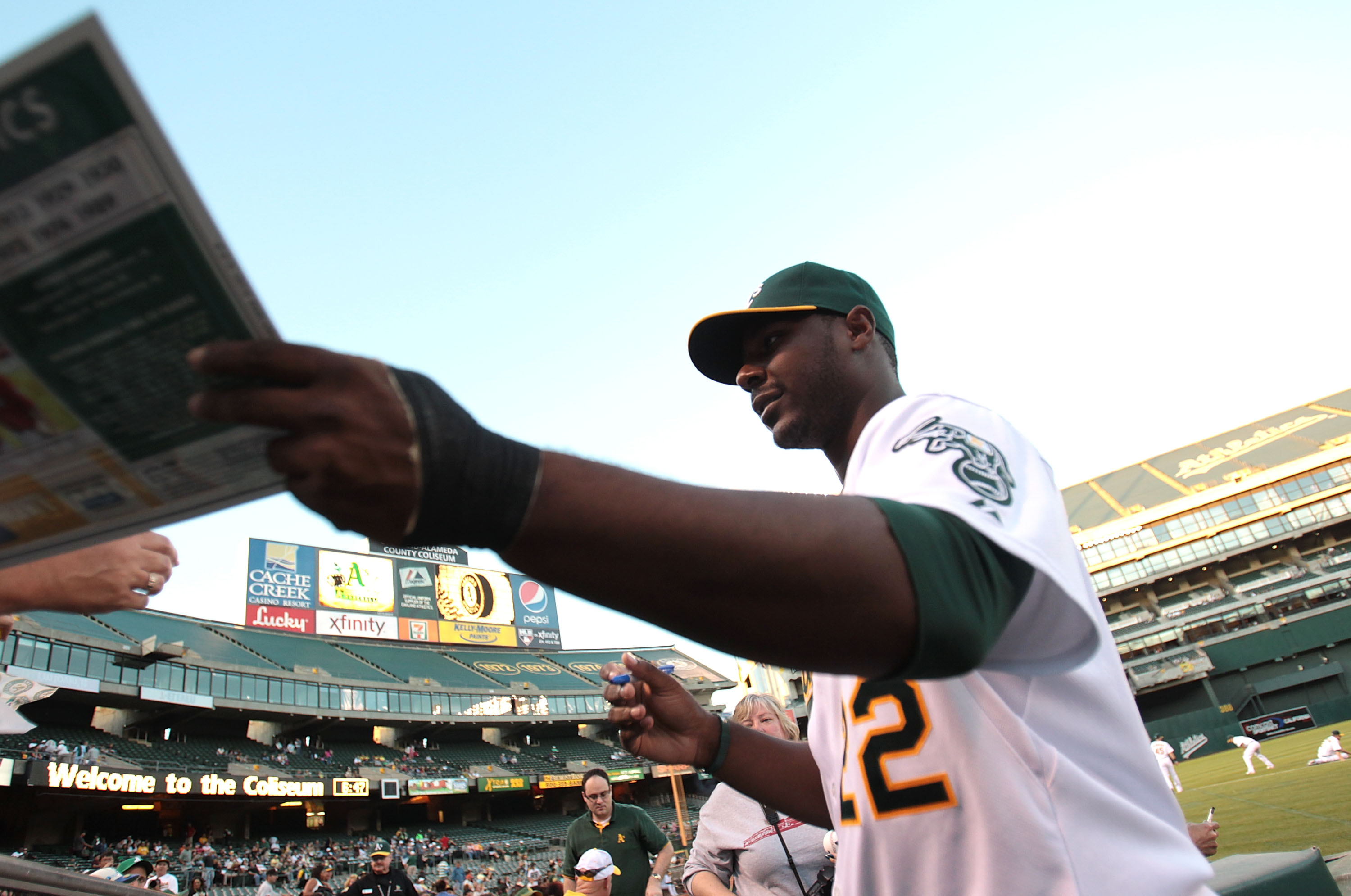 OAKLAND, CA - SEPTEMBER 24:  Chris Carter #22 of the Oakland Athletics signs autographs before a game against the Texas Rangers during a Major League Baseball game at the Oakland-Alameda County Coliseum on September 24, 2010 in Oakland, California. (Photo