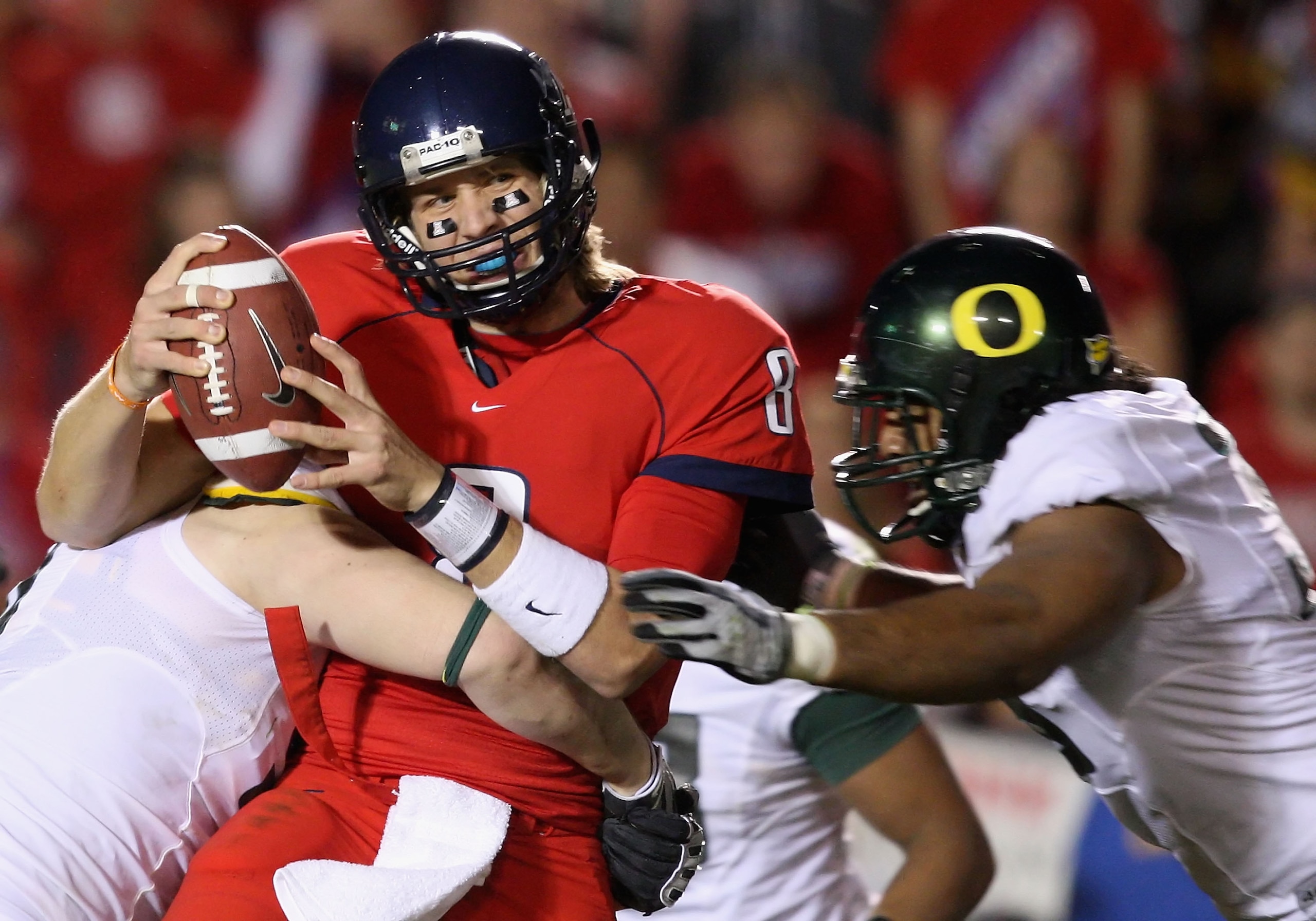 TUCSON, AZ - NOVEMBER 21:  Quarterback Nick Foles #8 of the Arizona Wildcats is sacked by Blake Ferras #90 and Will Tukuafu #39 of the Oregon Ducks during the college football game at Arizona Stadium on November 21, 2009 in Tucson, Arizona. The Ducks defe