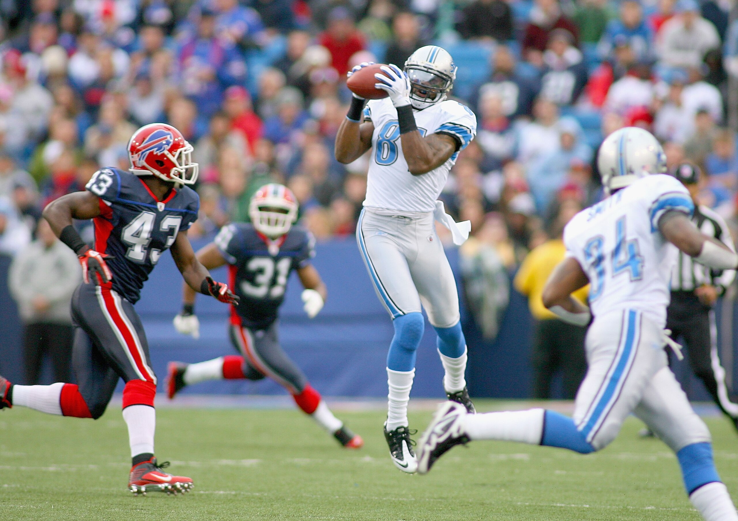 ORCHARD PARK, NY - NOVEMBER 14: Calvin Johnson #81 of the Detroit Lions makes a catch behind Bryan Scott #43 of the Buffalo Bills  at Ralph Wilson Stadium on November 14, 2010 in Orchard Park, New York. Buffalo won 14-12. (Photo by Rick Stewart/Getty Imag