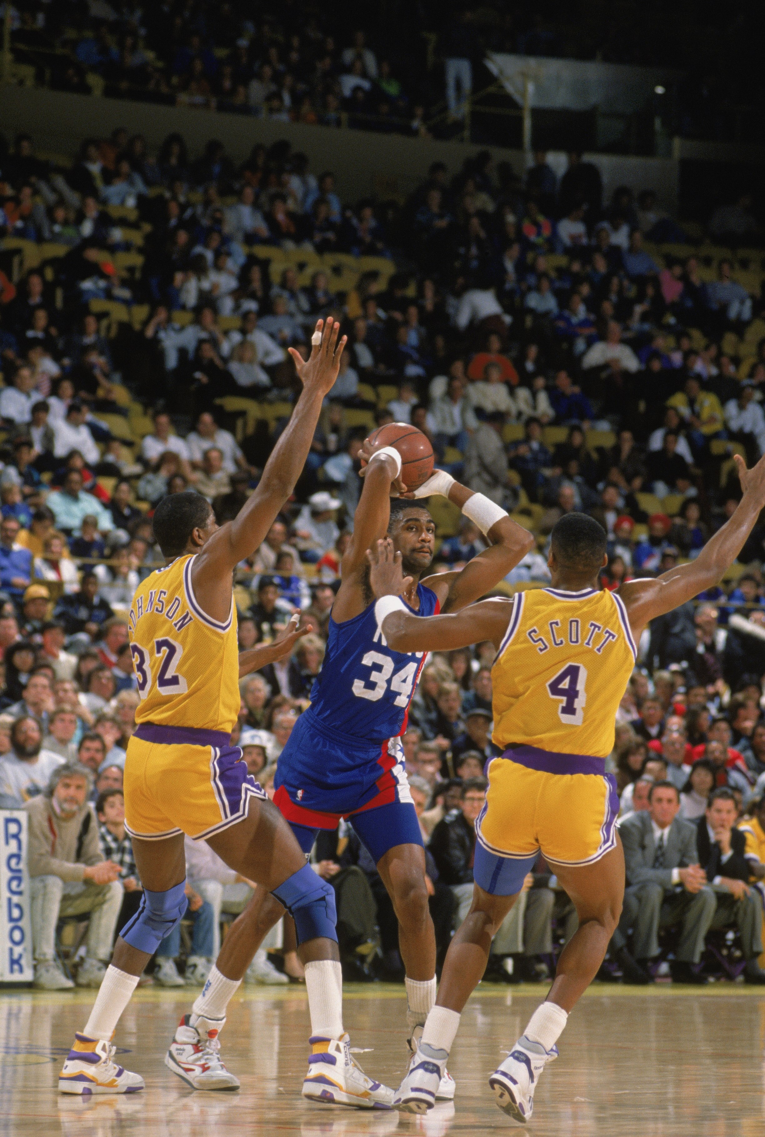 LOS ANGELES - 1990:  Chris Morris #34 of the New Jersey Nets looks to pass the ball over the defense of Magic Johnson #32 and Byron Scott #4 of the Los Angeles Lakers during the NBA game at the Great Western Forum in Los Angeles, California in 1990. NOTE