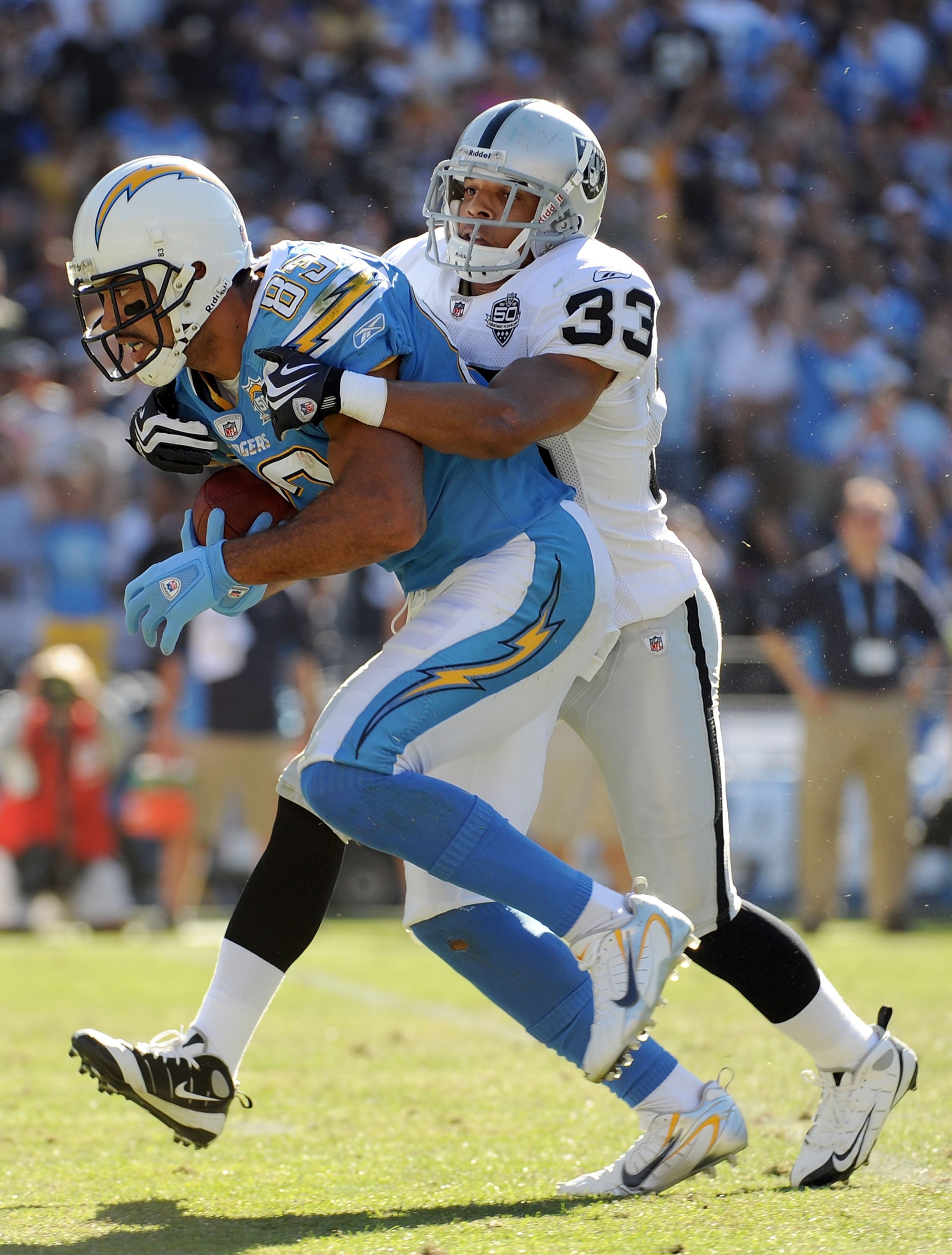 SAN DIEGO - NOVEMBER 01:  Vincent Jackson #83 of the San Diego Chargers is tackled by Tyvon Branch #33 of the Oakland Raiders during the game at Qualcomm Stadium on November 1, 2009 in San Diego California. The Chargers defeated the Raiders 24-16. (Photo