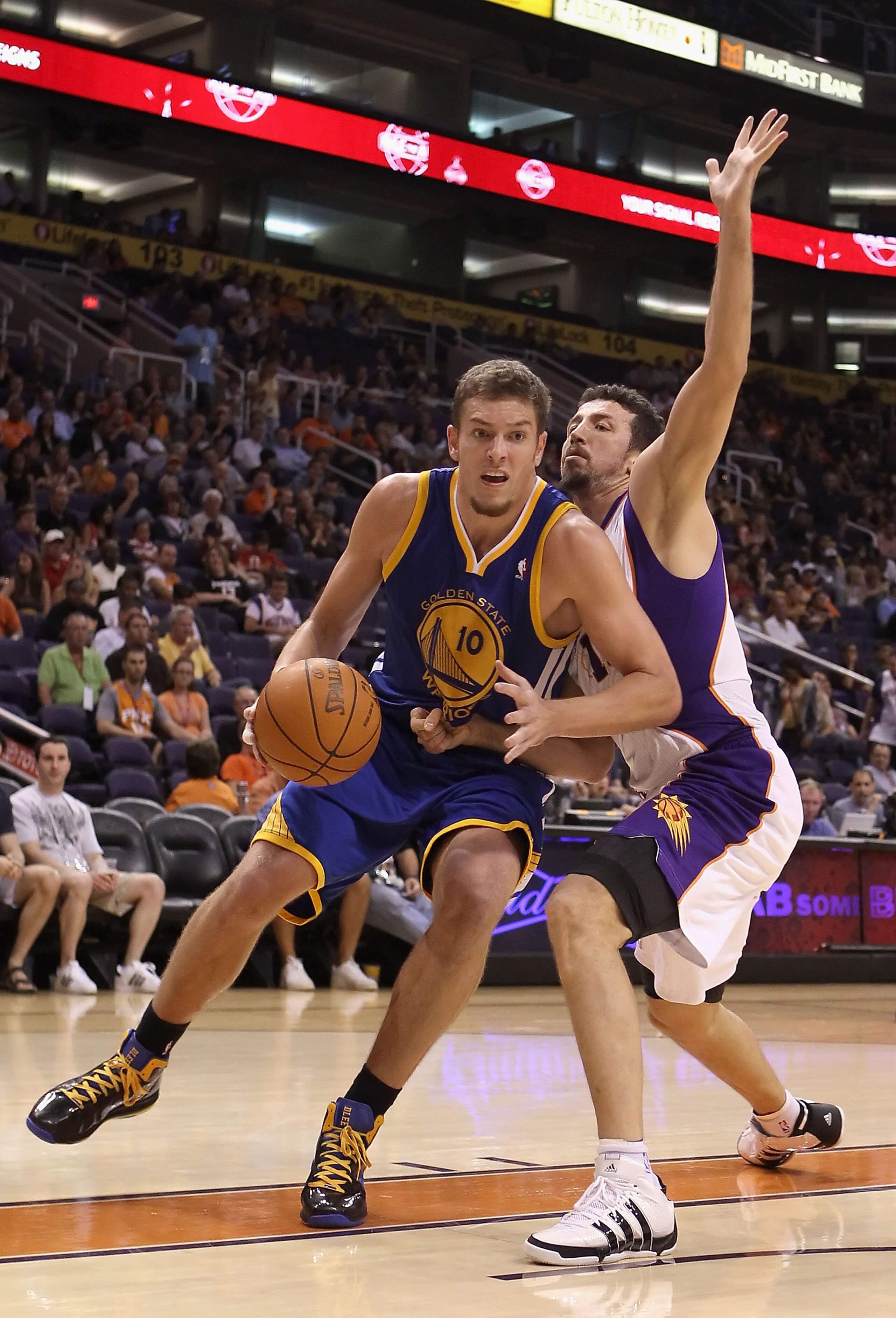 PHOENIX - OCTOBER 19:  David Lee #10 of the Golden State Warriors handles the ball under pressure from Hedo Turkoglu #19 of the Phoenix Suns during the preseason NBA game at US Airways Center on October 19, 2010 in Phoenix, Arizona. NOTE TO USER: User exp