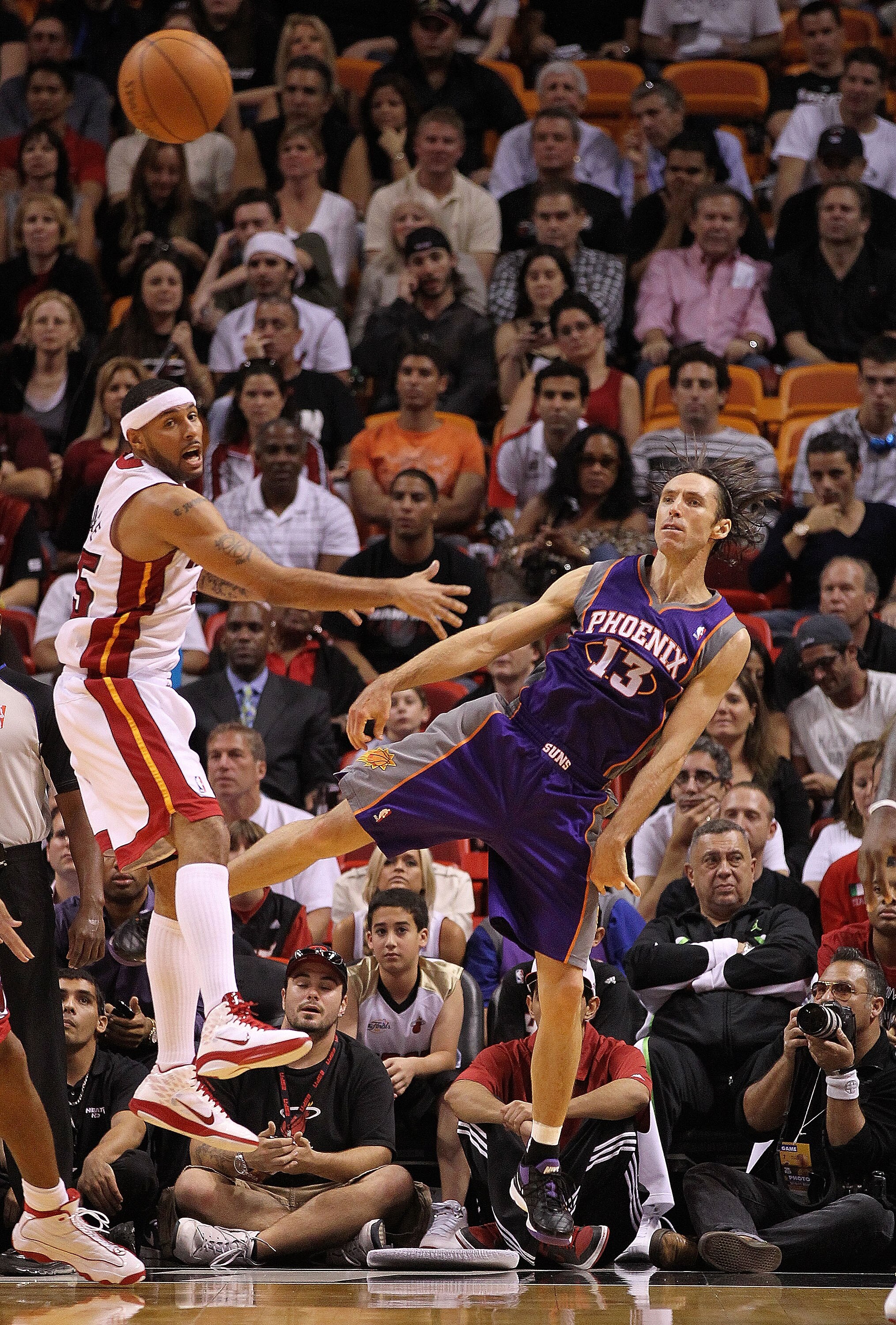 MIAMI - NOVEMBER 17:  Steve Nash #13  of the Phoenix Suns passes the ball around Eddie House #55 during a game against the  Miami Heat at American Airlines Arena on November 17, 2010 in Miami, Florida. NOTE TO USER: User expressly acknowledges and agrees