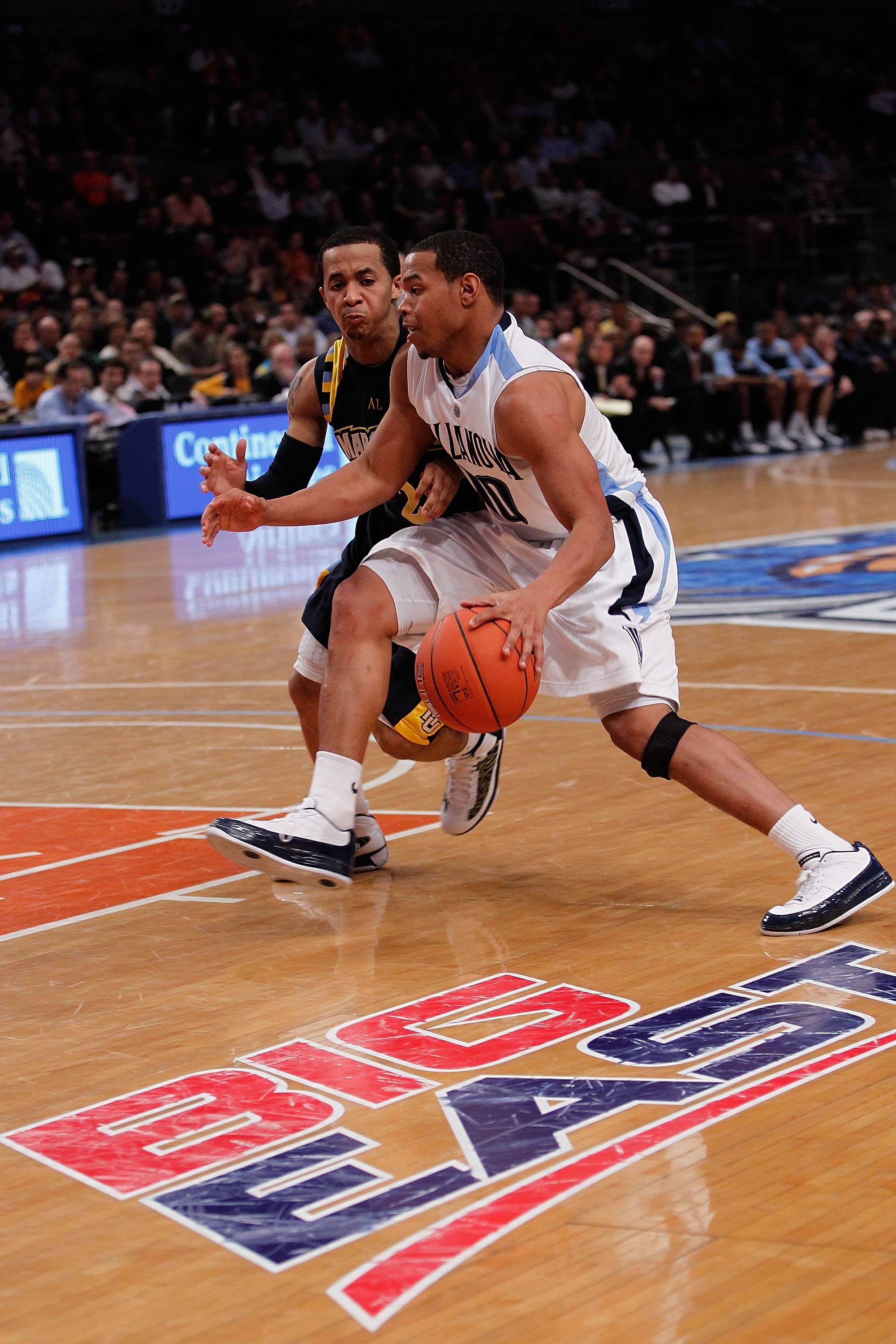 NEW YORK - MARCH 11:  Corey Fisher #10 of the Villanova Wildcats handles the ball against Maurice Acker #2 of the Marquette Golden Eagles during the quarterfinal of the 2010 NCAA Big East Tournament at Madison Square Garden on March 11, 2010 in New York C