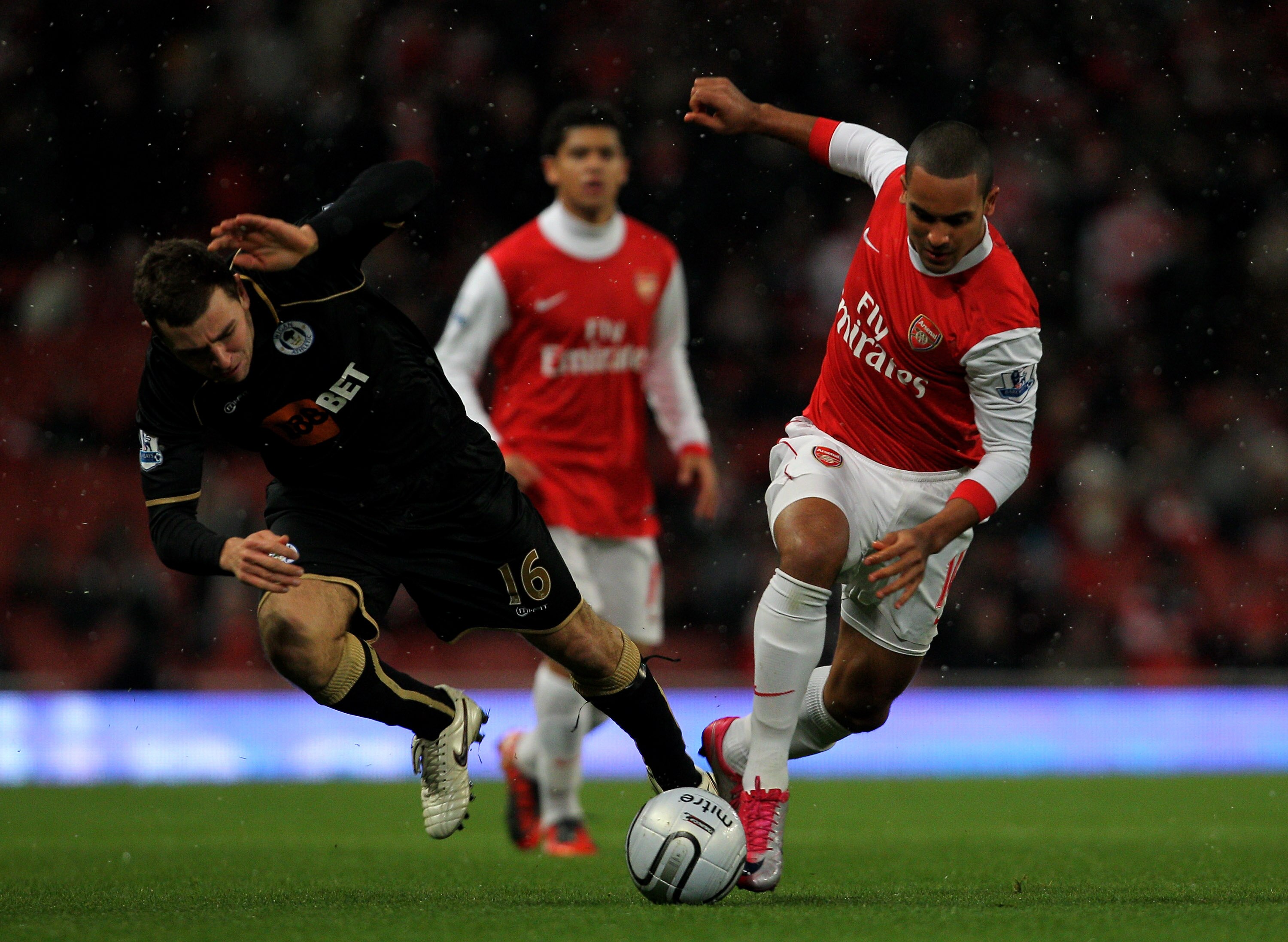 LONDON, ENGLAND - NOVEMBER 30:  Theo Walcott (R) of Arsenal in action against James McCarthur of Wigan as Denilson of Arsenal looks on during the Carling Cup quarter final match between Arsenal and Wigan Athletic at the Emirates Stadium on November 30, 20