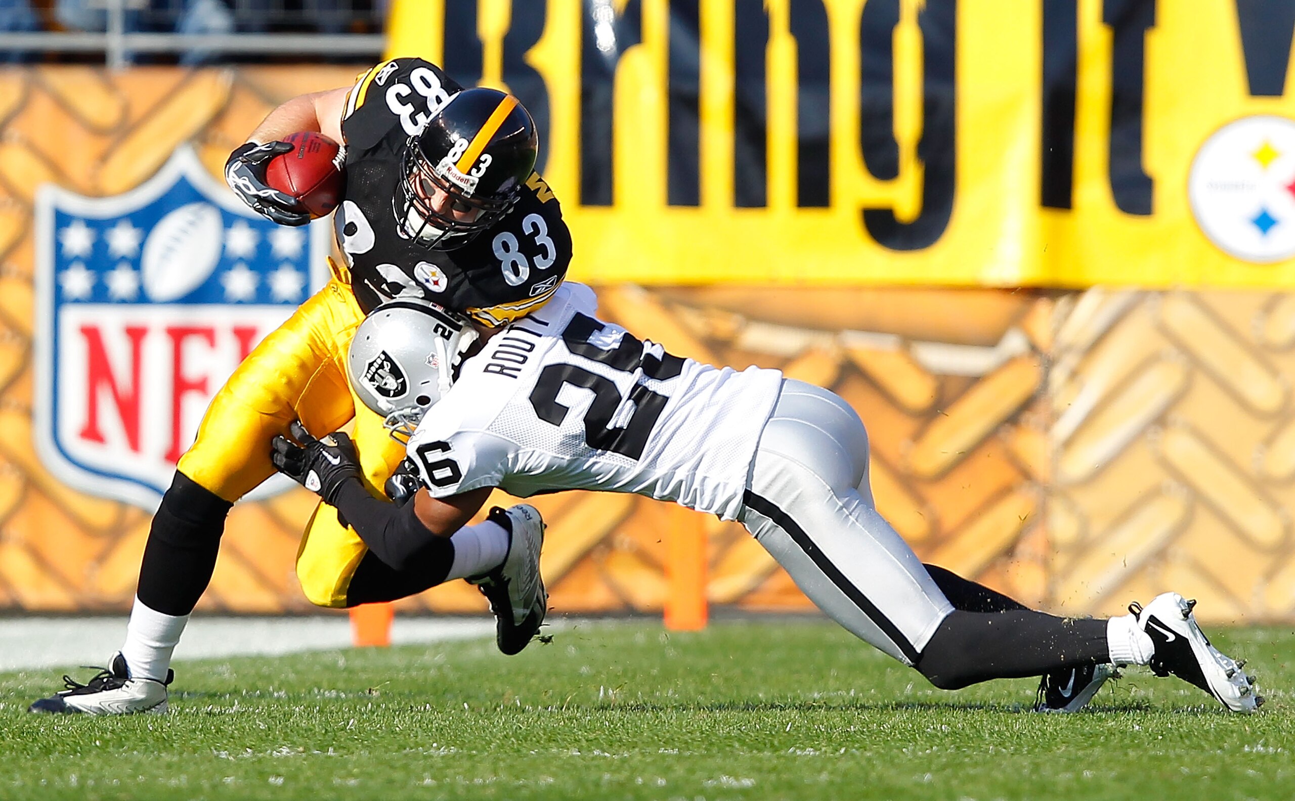 PITTSBURGH - NOVEMBER 21:  Heath Miller #83 of the Pittsburgh Steelers attempts to run through a tackle by Stanford Routt #26 of the Oakland Raiders during the game on November 21, 2010 at Heinz Field in Pittsburgh, Pennsylvania.  (Photo by Jared Wickerha
