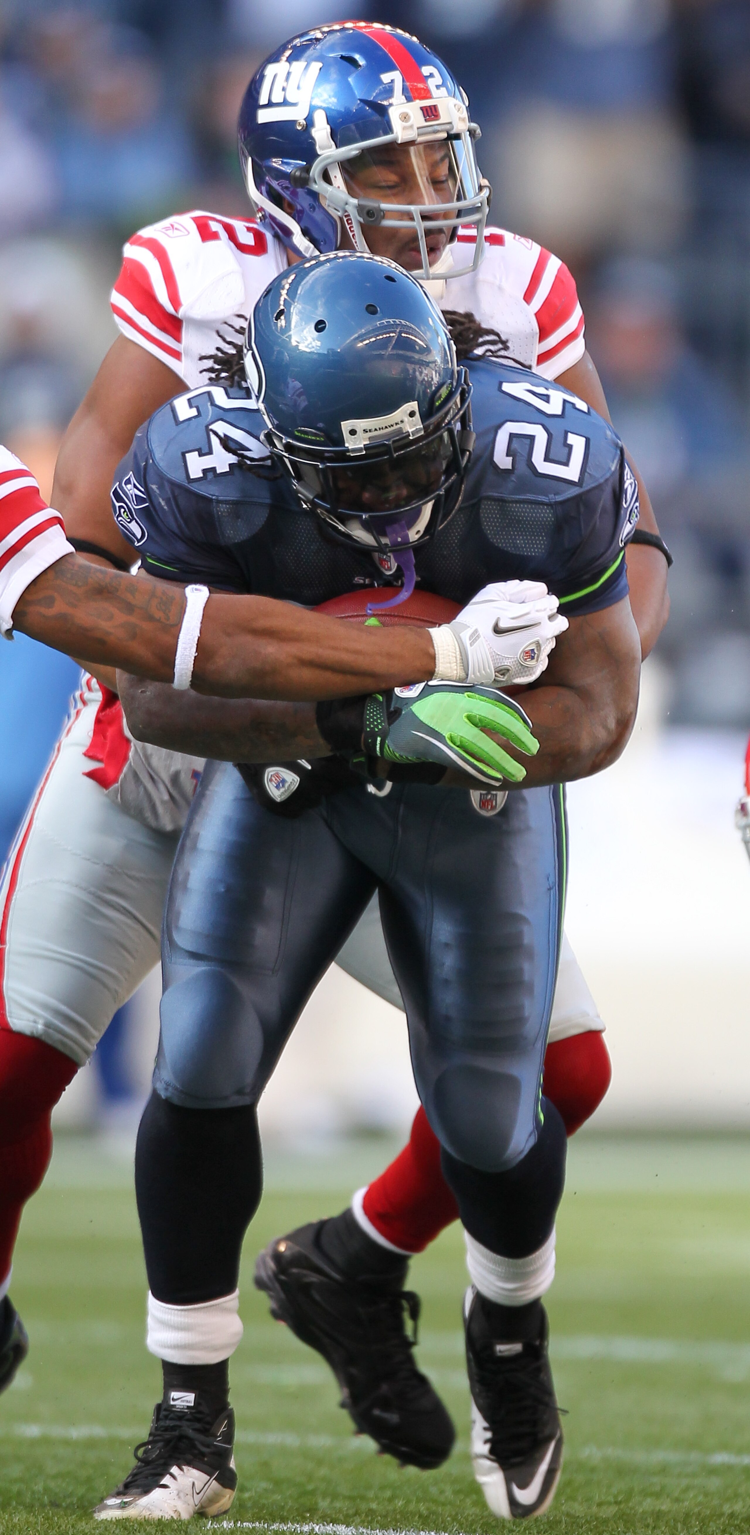 SEATTLE - NOVEMBER 07:  Running back Marshawn Lynch #24 of the Seattle Seahawks is tackled by Osi Umenyiora #72 of the New York Giants at Qwest Field on November 7, 2010 in Seattle, Washington. The Giants defeated the Seahawks 41-7. (Photo by Otto Greule