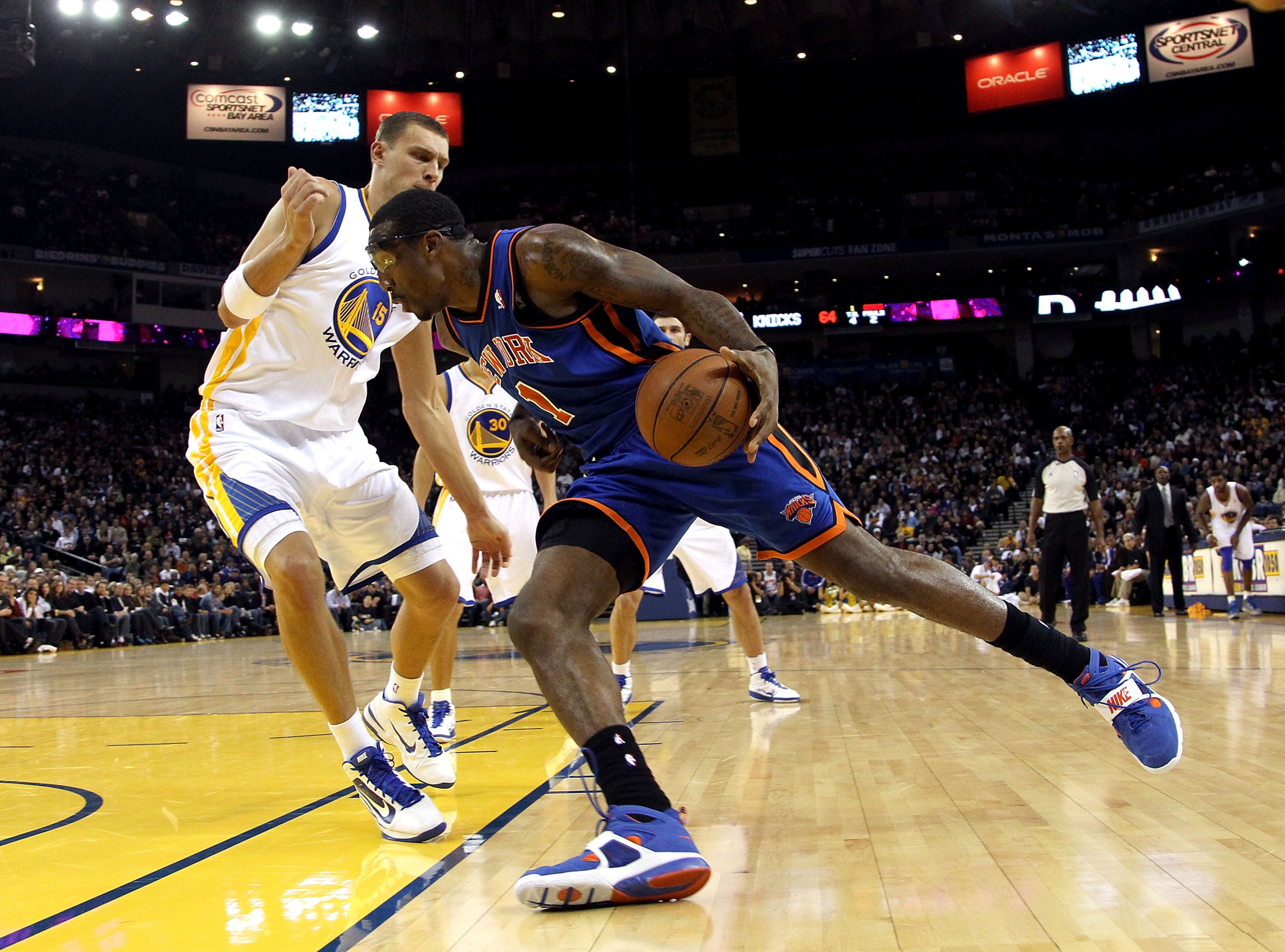 OAKLAND, CA - NOVEMBER 19:  Amar'e Stoudemire #1 of the New York Knicks dribbles past Andris Biedrins #15 of the Golden State Warriors at Oracle Arena on November 19, 2010 in Oakland, California. NOTE TO USER: User expressly acknowledges and agrees that,