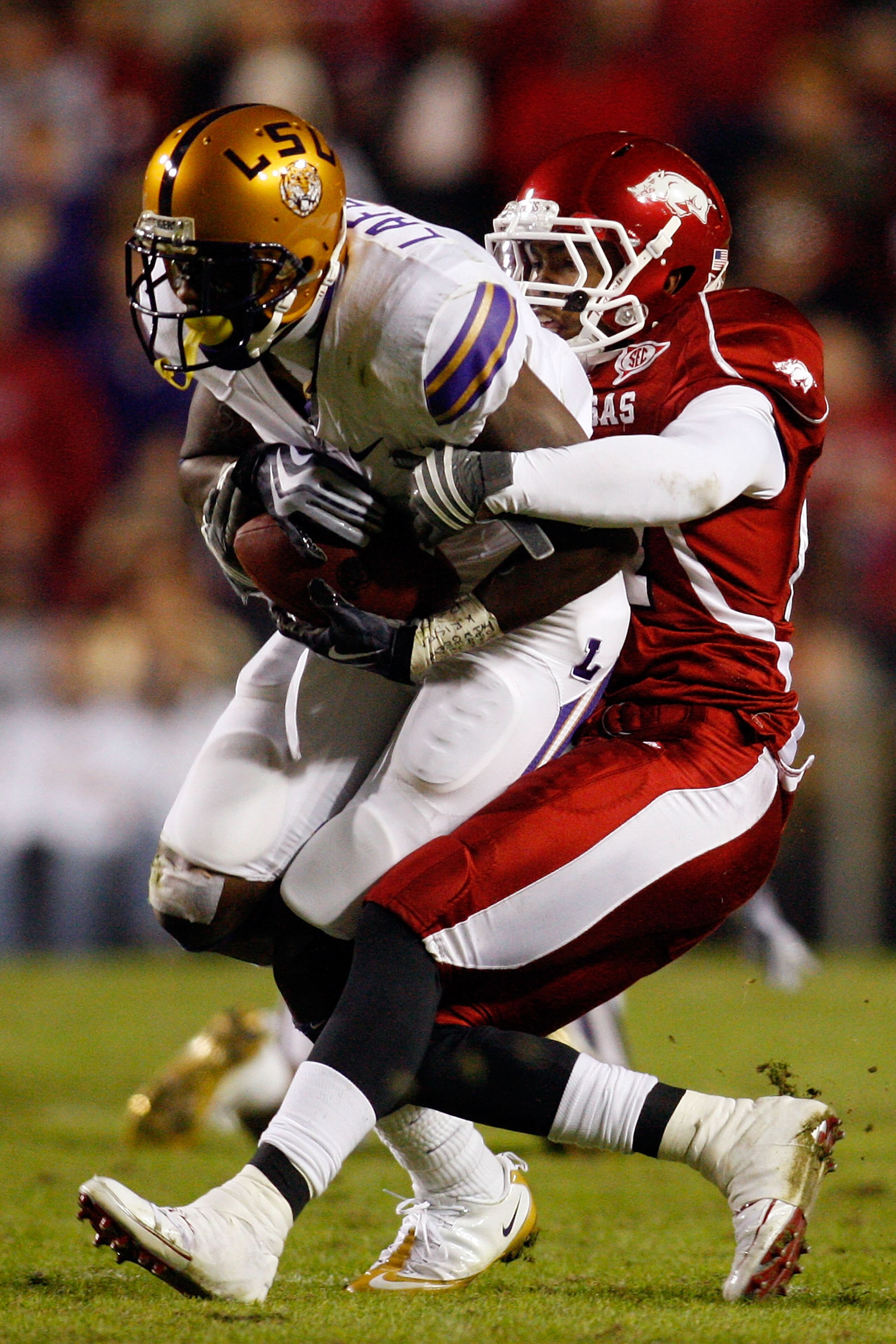 BATON ROUGE, LA - NOVEMBER 28:  Brandon LaFell #1 of the LSU Tigers is tackled by Jerell Norton #27 of the Arkansa Razorbacks at Tiger Stadium on November 28, 2009 in Baton Rouge, Louisiana.  The Tigers defeated the Razorbacks 33-30 in overtime.  (Photo b