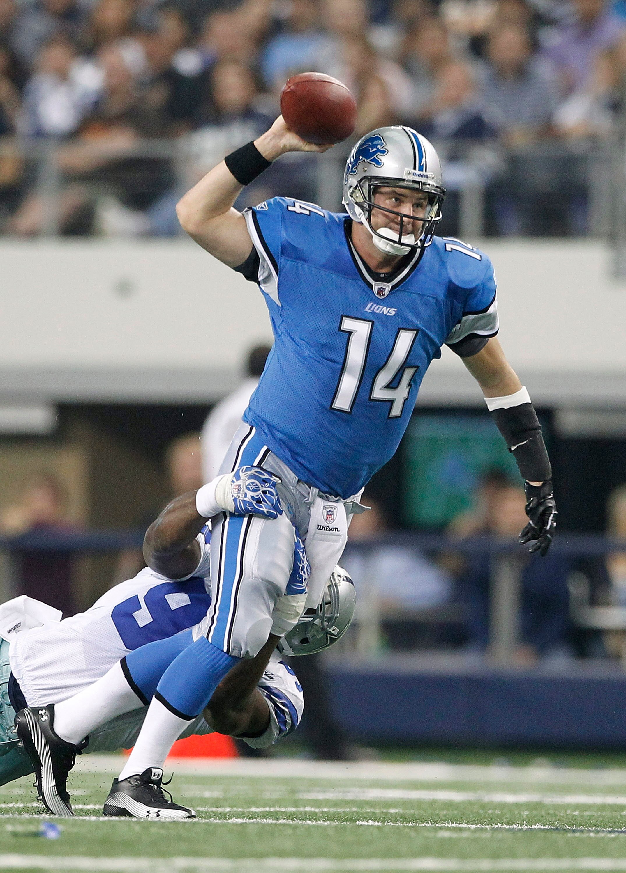 ARLINGTON, TX - NOVEMBER 21: Shaun Hill #14 of the Detroit Lions throws the ball as DeMarcus Ware #94 of the Dallas Cowboys makes the sack during the game at Dallas Stadium on November 21, 2010 in Arlington, Texas. The Cowboys defeated the Lions 35-19.  (