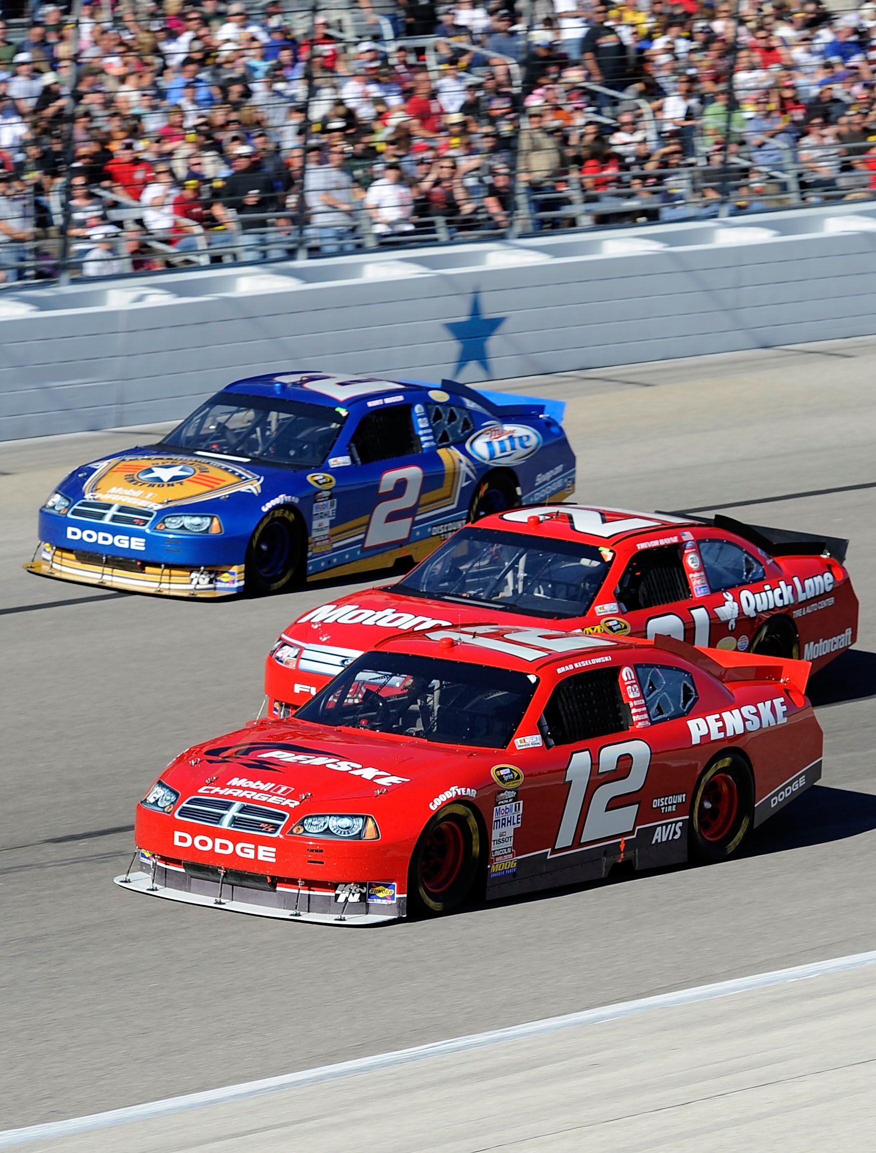 FORT WORTH, TX - NOVEMBER 07:  Brad Keselowski, driver of the #12 Penske Dodge, races Trevor Bayne, driver of the #21 Motorcraft/Quick Lane Ford, and Kurt Busch, driver of the #2 Operation Home Front/Miller Lite Dodge, during the NASCAR Sprint Cup Series