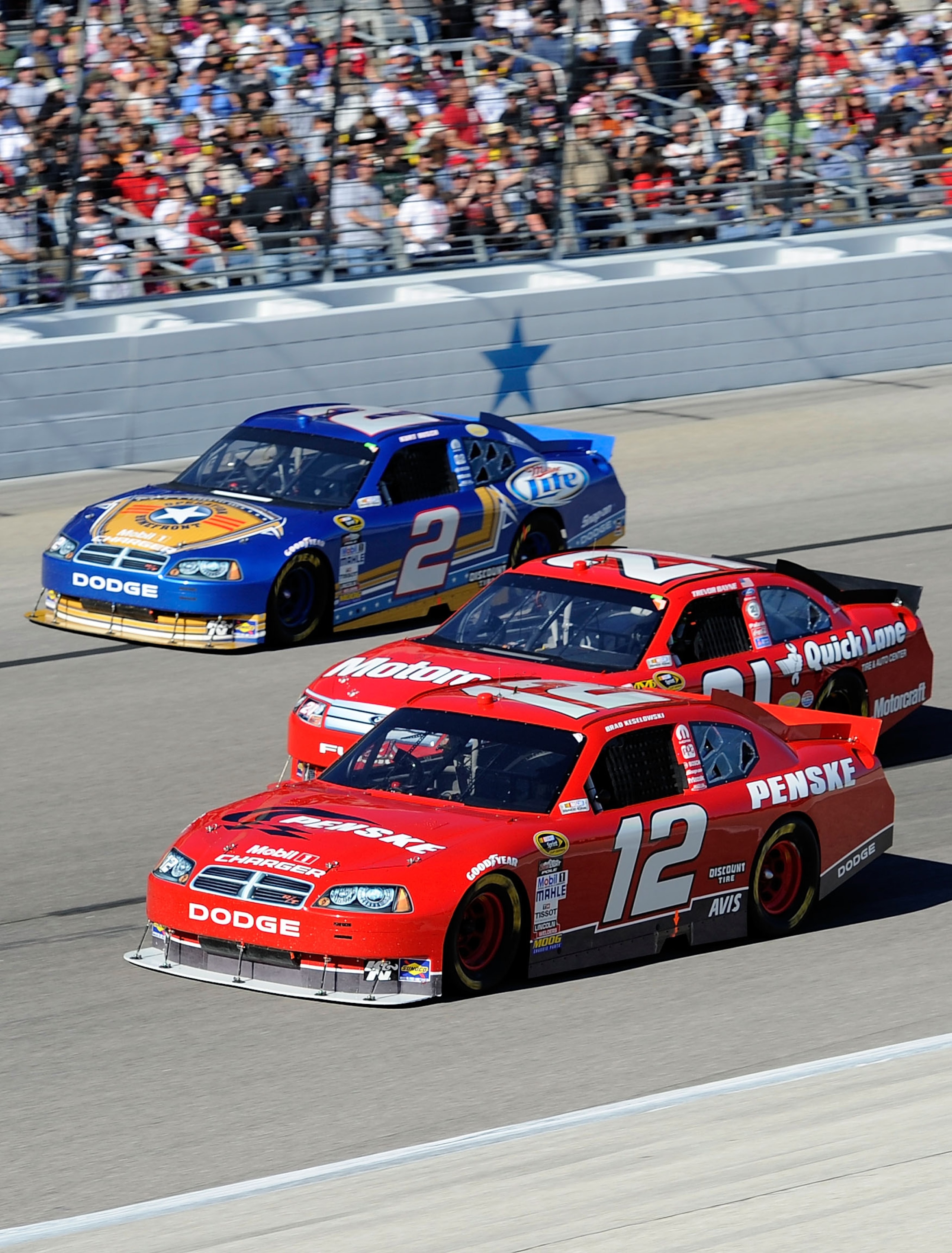FORT WORTH, TX - NOVEMBER 07:  Brad Keselowski, driver of the #12 Penske Dodge, races Trevor Bayne, driver of the #21 Motorcraft/Quick Lane Ford, and Kurt Busch, driver of the #2 Operation Home Front/Miller Lite Dodge, during the NASCAR Sprint Cup Series