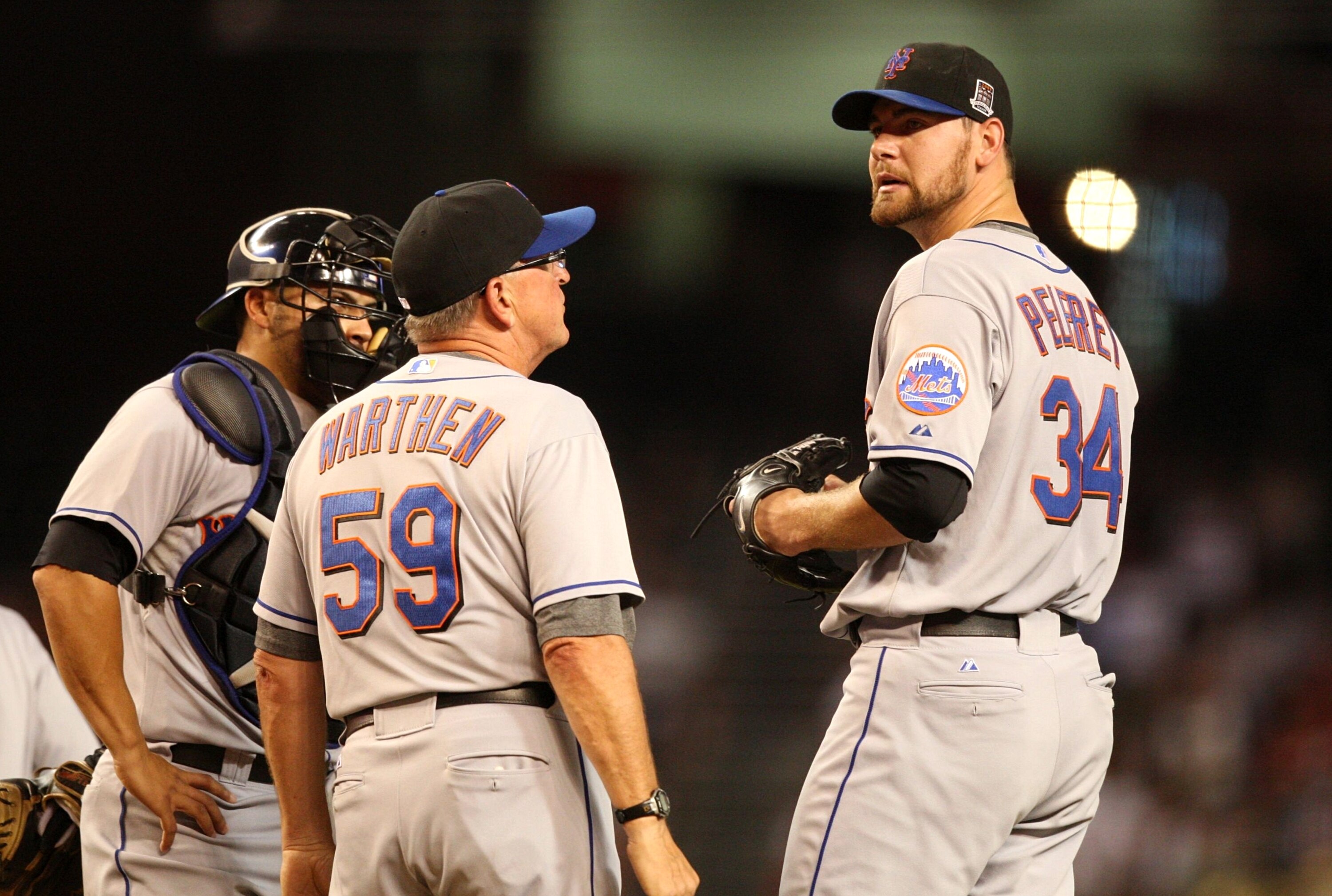 PHOENIX - AUGUST 10: Starting pitcher Mike Pelfrey #34 of the New York Mets is met on the mound by pitching coach Dan Warthen #59 after giving up three runs in the second inning to the Arizona Diamondbacks at Chase Field on August 10, 2009 in Phoenix, Ari