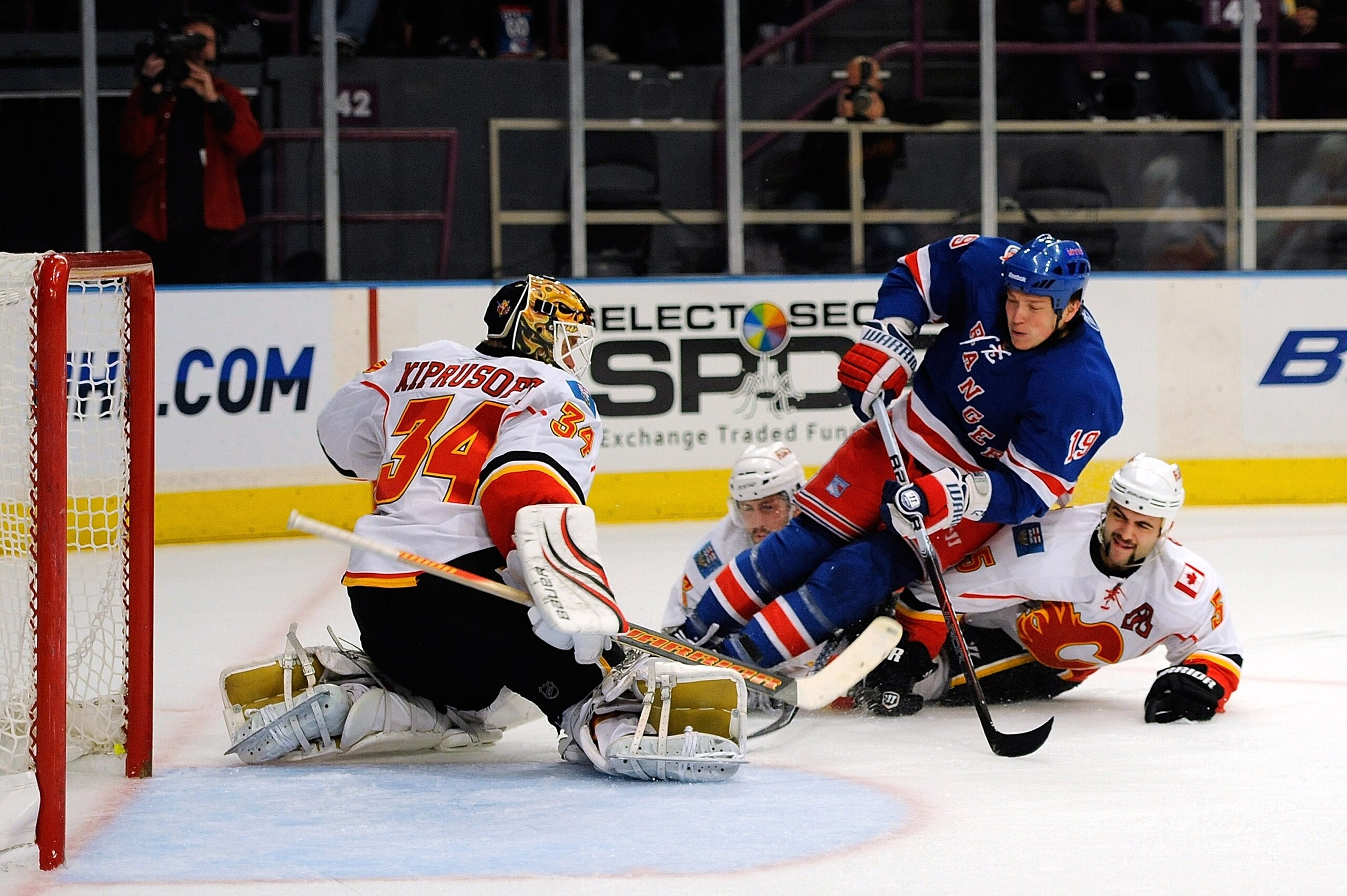 NEW YORK - NOVEMBER 22:  Ruslan Fedotenko #19 of the New York Rangers defended by Mark Giordano #5 of the Calgary Flames attempting a shot on goal against Mikka Kiprusoff #34 of the Calgary Flames during the second period on November 22, 2010 at Madison S