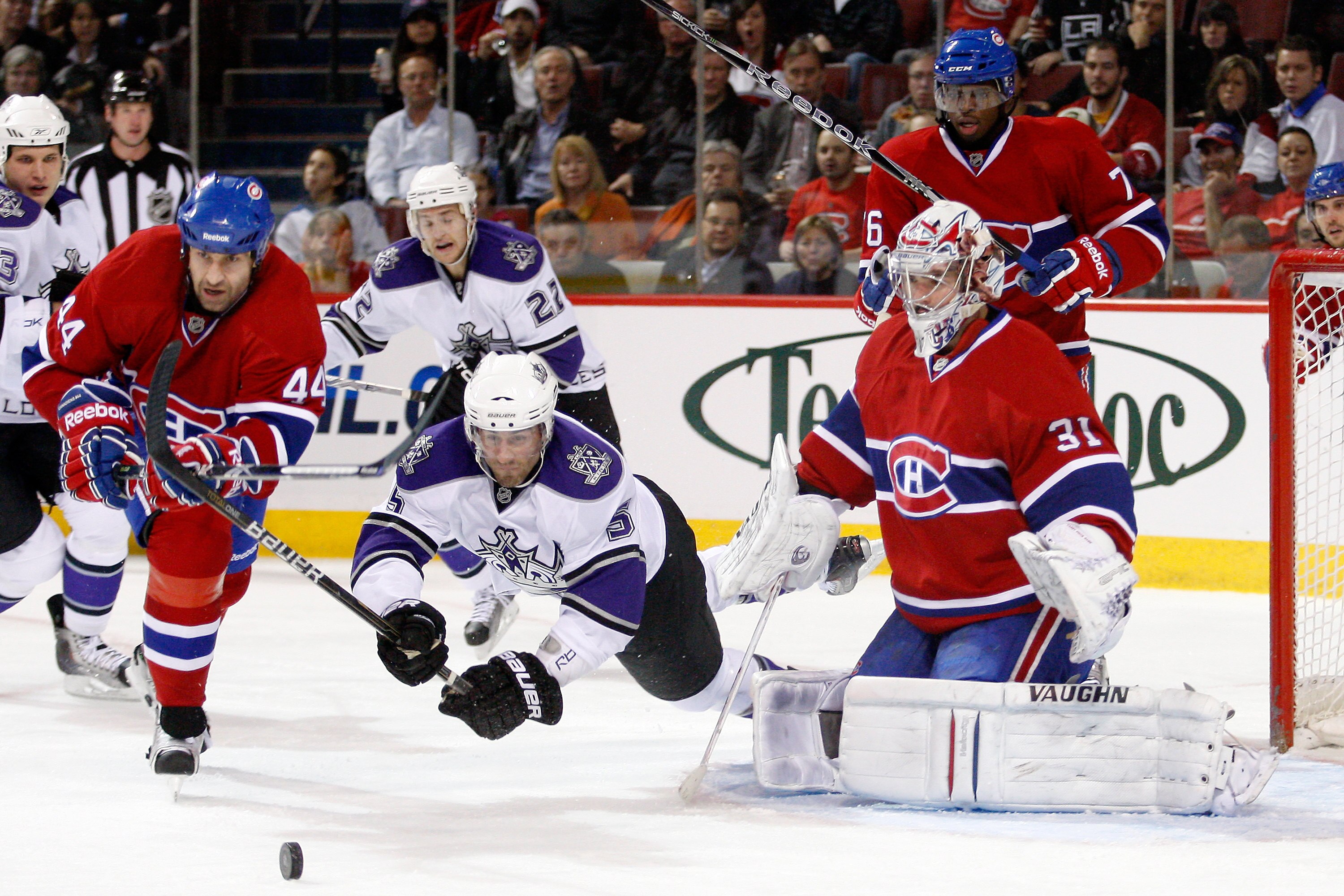 MONTREAL- NOVEMBER 24:  Peter Harrold #5 of the Los Angeles Kings dives for the loose puck in front of Carey Price #31 and Roman Hamrlik #44 of the Montreal Canadiens during the NHL game at the Bell Centre on November 24, 2010 in Montreal, Quebec, Canada.