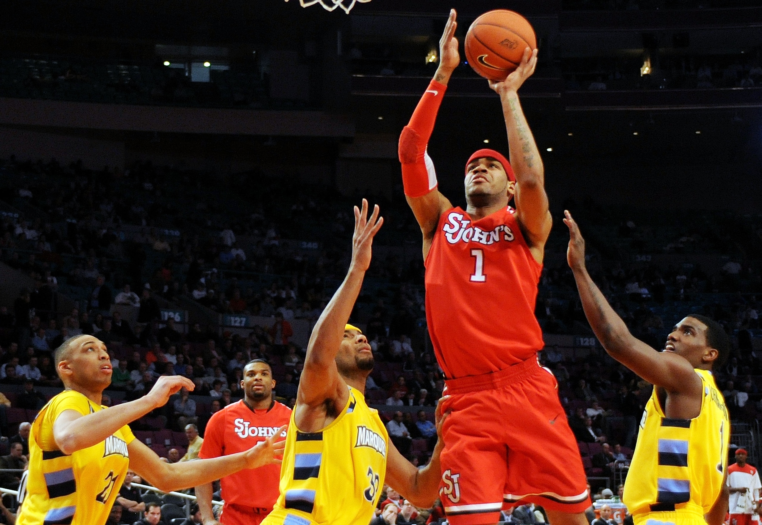 NEW YORK - MARCH 10:  D.J. Kennedy #1 of the St. John's Red Storm goes to the hoop against Joseph Fulce #21, Lazar Hayward #32 and Darius Johnson-Odom #1 of the Marquette Golden Eagles during the second round of 2010 NCAA Big East Tournament at Madison Sq