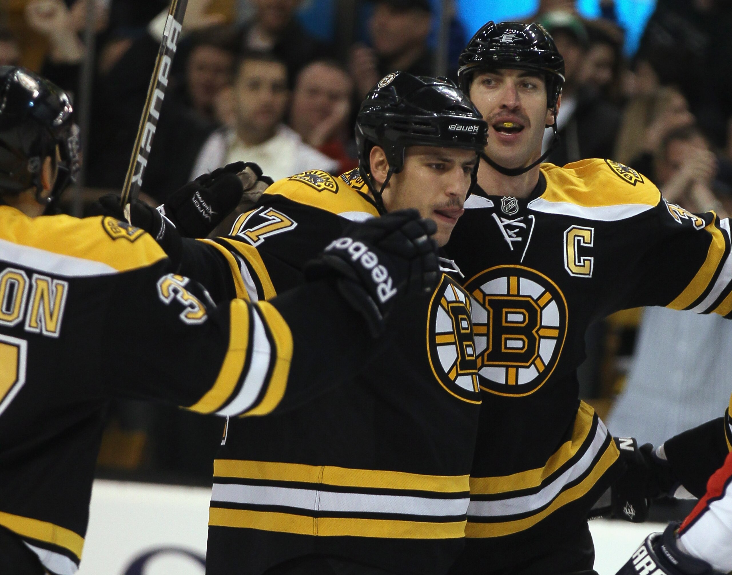BOSTON - NOVEMBER 18:  Milan Lucic #17 of the Boston Bruins is congratulated by teammates Patrice Bergeron #37 and Zdeno Chara #33 after Lucic scored the firsts goal of the game againstthe Florida Panthers on November 18, 2010 at the TD Garden in Boston,