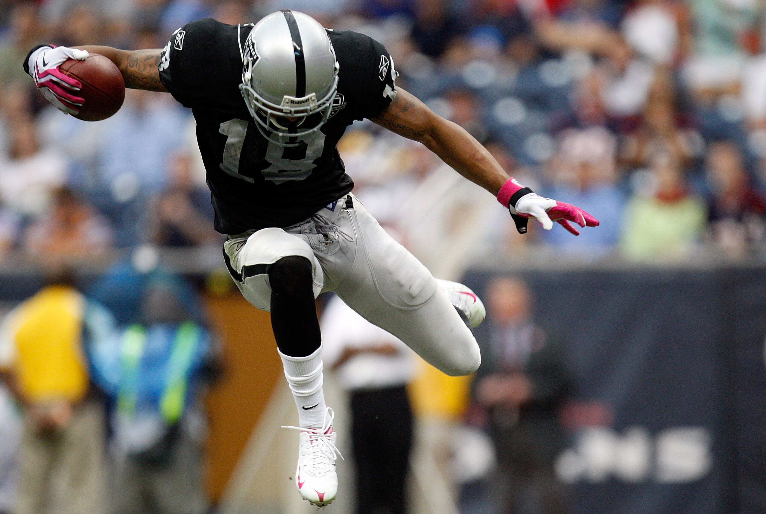HOUSTON - OCTOBER 04:  Wide receiver Louis Murphy #18 of the Oakland Raiders jumps over a tackle by the Houston Texans at Reliant Stadium on October 4, 2009 in Houston, Texas.  (Photo by Ronald Martinez/Getty Images)