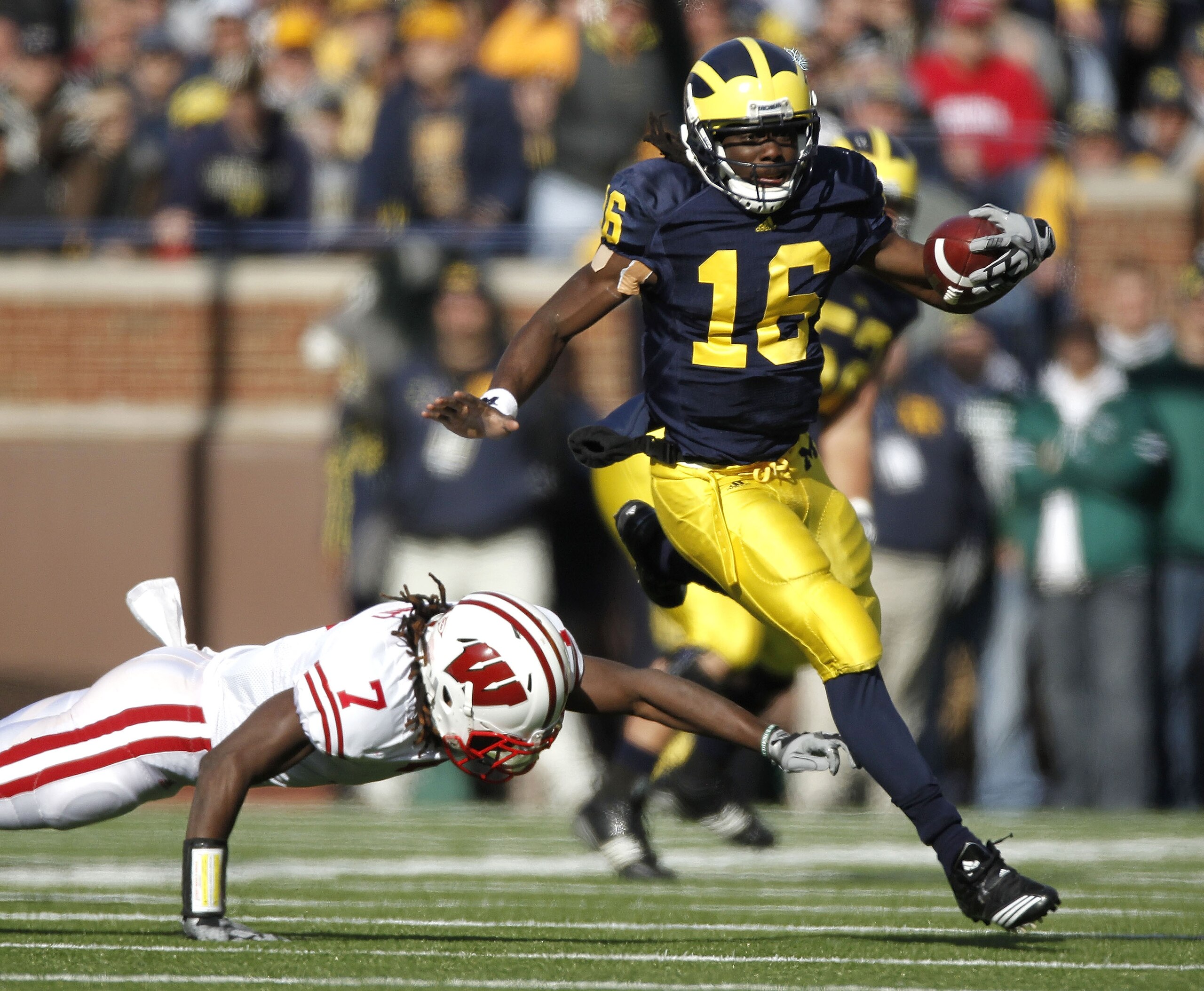 ANN ARBOR, MI - NOVEMBER 20: Denard Robinson #16 of the Michigan Wolverines gets around the tackle of Aaron Henry #7 of the Wisconsin Badgers at Michigan Stadium on November 20, 2010 in Ann Arbor, Michigan.  (Photo by Gregory Shamus/Getty Images)