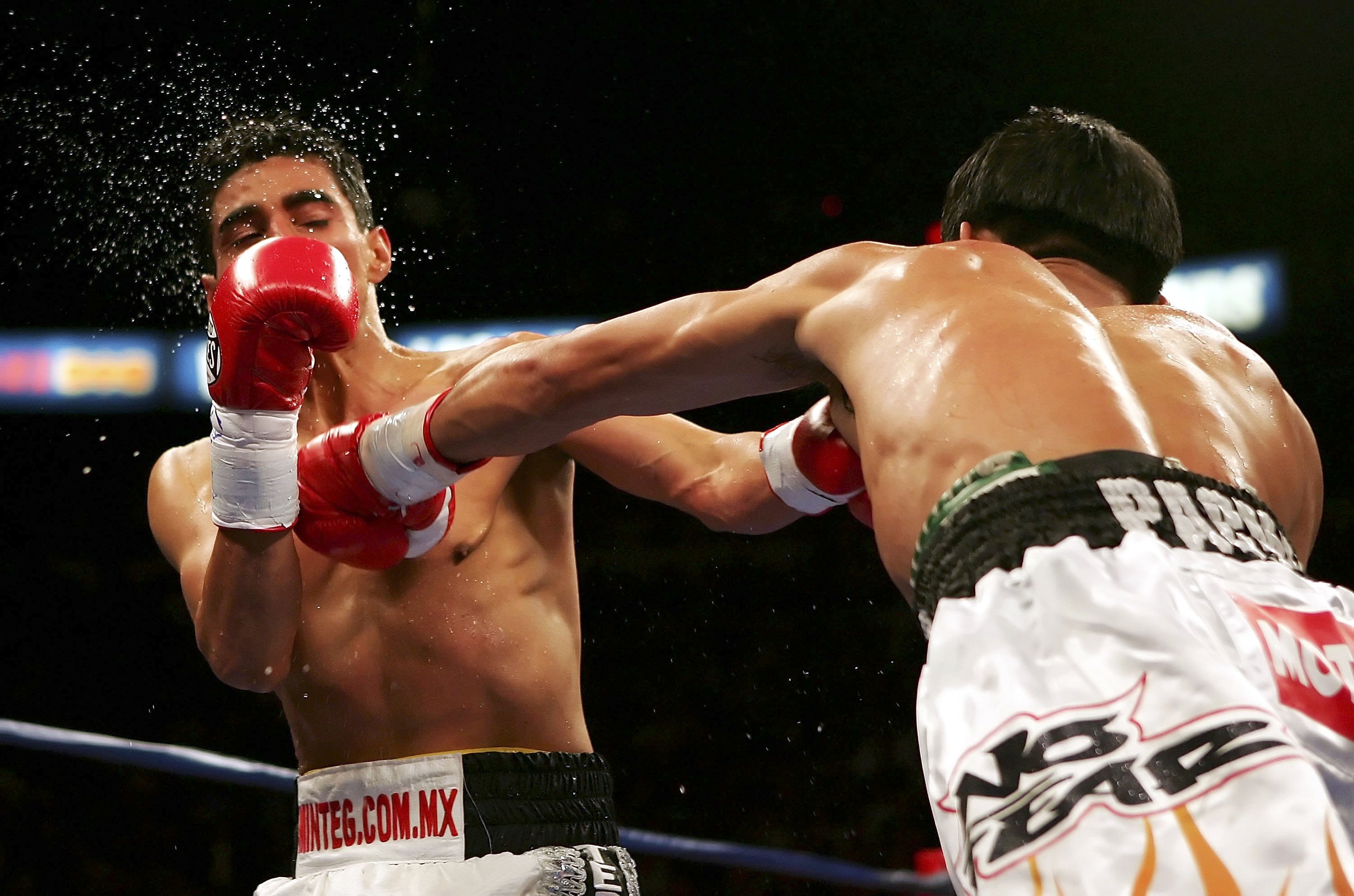 LAS VEGAS - NOVEMBER 18:  (R-L) Manny Pacquiao of the Philippines connects with a left to the face of Erik Morales of Mexico during their super featherweight bout at the Thomas & Mack Center on November 18, 2006 in Las Vegas, Nevada. Pacquiao won after a 