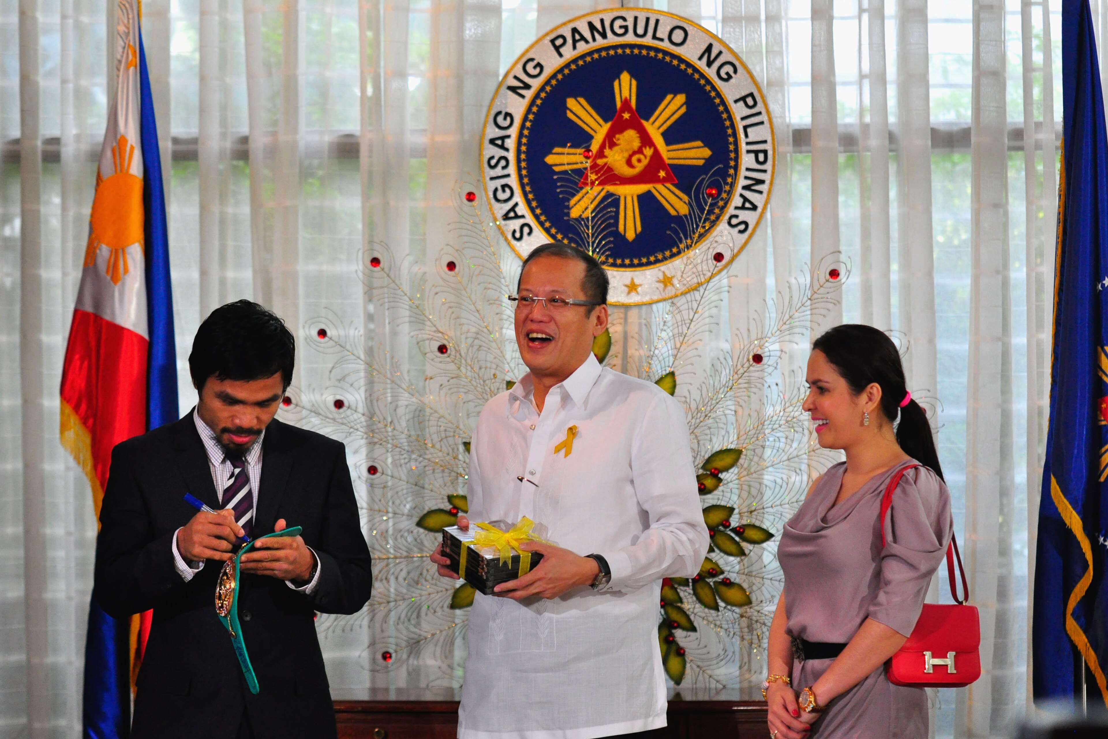 MANILA, PHILIPPINES - NOVEMBER 20:  Boxer and congressman, Manny Pacquiao gives President Benigno Aquino III a shirt and memorabilia following his win of the WBC super welterweight crown against Mexican Antonio Margarito on November 20, 2010 in Manila, Ph