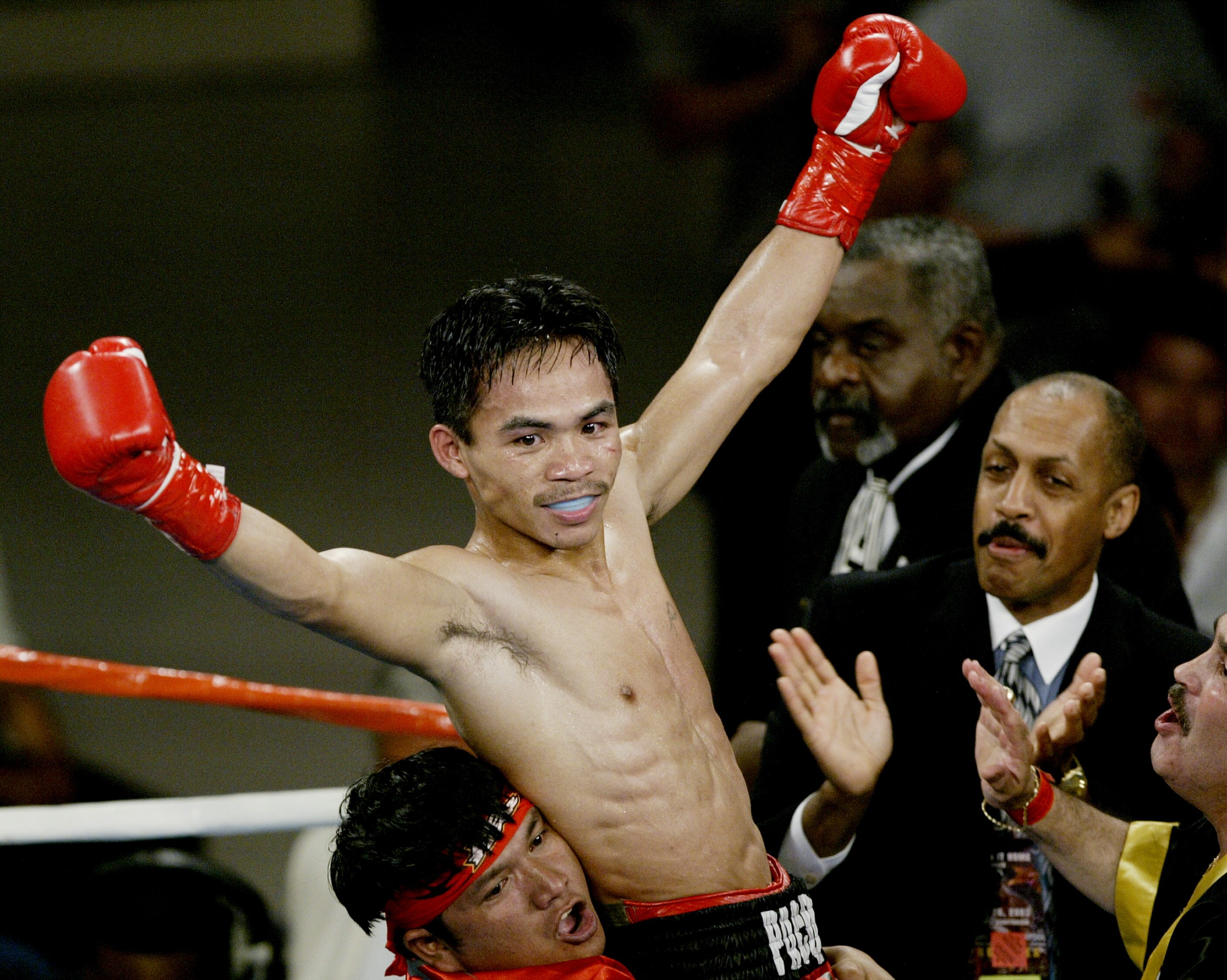 LOS ANGELES - JULY 26:  IBF Jr. Featherweight Champion Manny Pacquiao of the Philippines celebrates defeating Emmanuel Lucero to hold onto his title on July 26, 2003 at the Olympic Auditorium in Los Angeles, California. Manny Pacquiao won by knockout in t