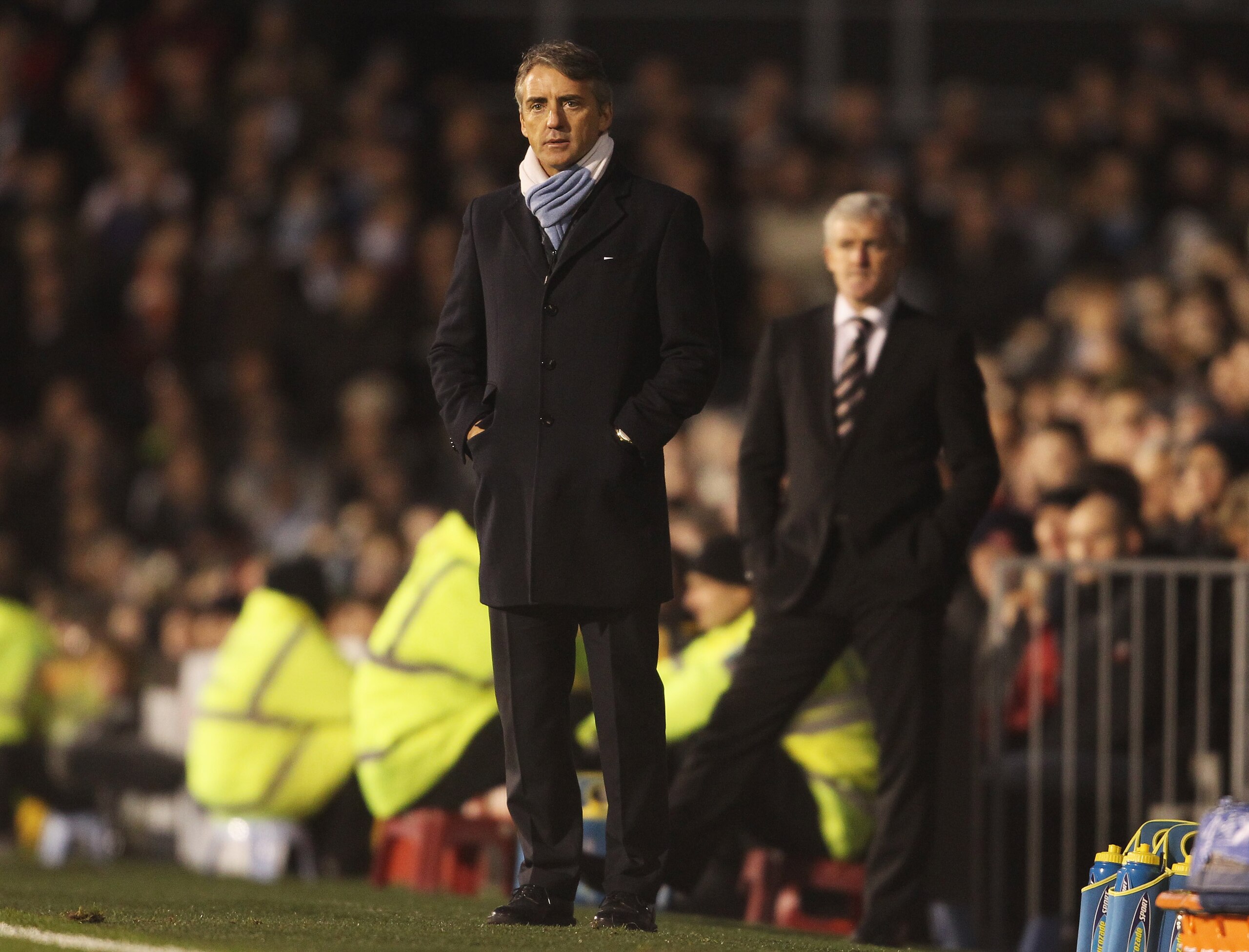 LONDON, ENGLAND - NOVEMBER 21:  Manchester City manager Roberto Mancini looks on with Fulham manager Mark Hughes during the Barclays Premier League match between Fulham and Manchester City at Craven Cottage on November 21, 2010 in London, England.  (Photo