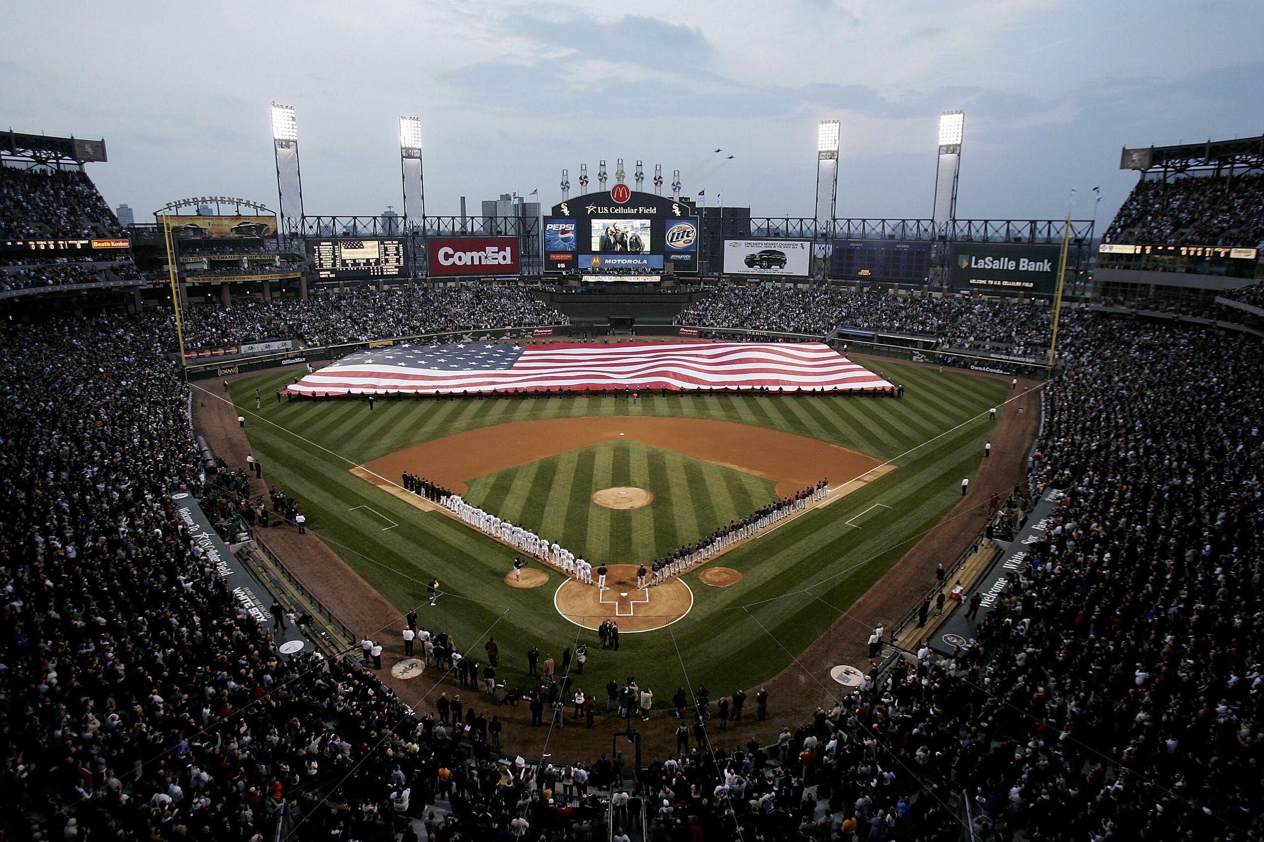 CHICAGO - APRIL 02:  A giant U.S. flag is unfurled during the National Anthem prior to the start of the Opening Day game between the Cleveland Indians and the Chicago White Sox on April 2, 2006 at U.S. Cellular Field in Chicago, Illinois.  (Photo by Peter