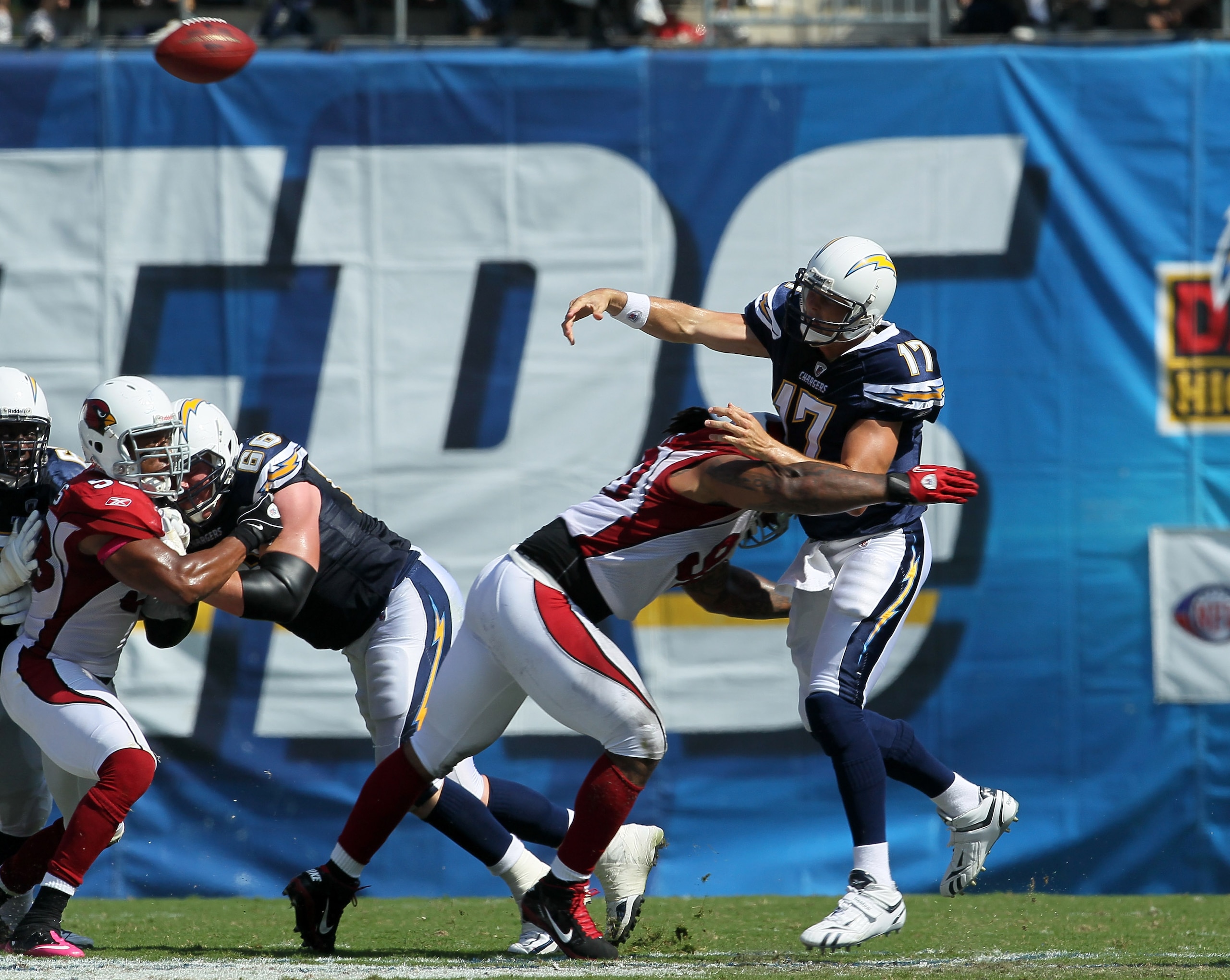 SAN DIEGO - OCTOBER 03:  Quarterback Philip Rivers of the San Diego Chargers throws a pass as he is hit by defensive tackle Darnell Dockett #90 of the Arizona Cardinals at Qualcomm Stadium on October 3, 2010 in San Diego, California.   The Chargers won 41